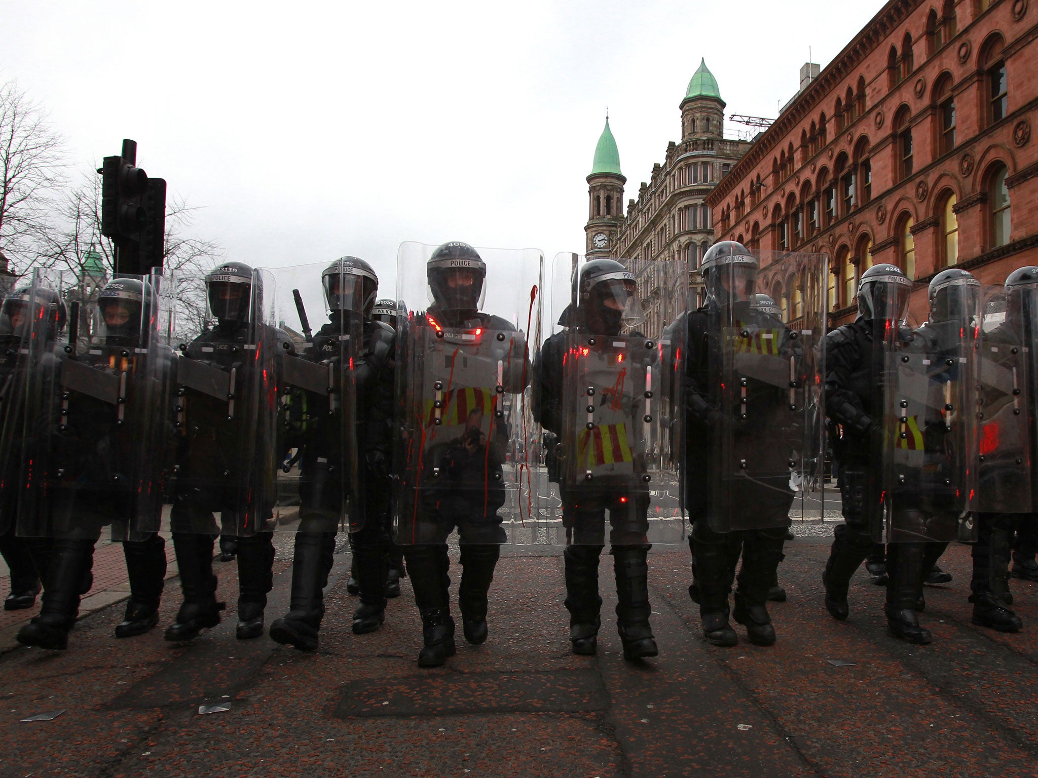 olice in riot gear march behind loyalist protesters after a demonstration outside City Hall in Belfast, Northern Ireland on January 5, 2013.