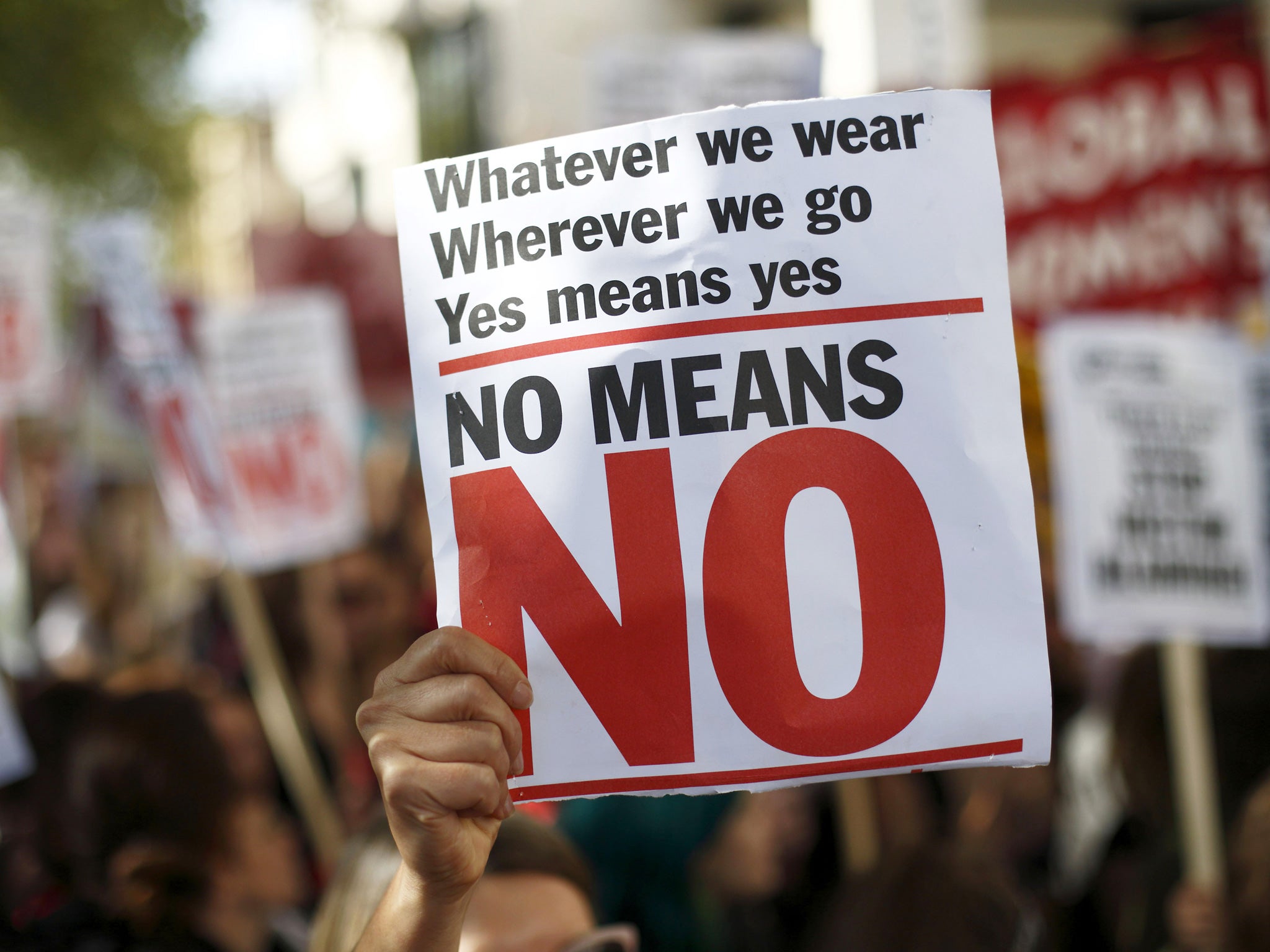 A woman holds a banner in a London protest against the police and courts