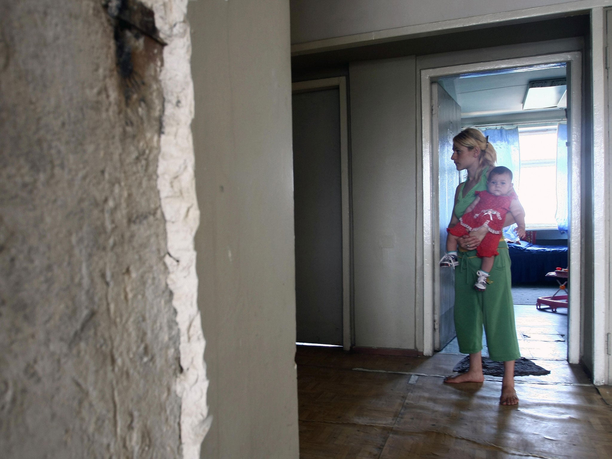 A Georgian woman from South Ossetia carries her baby on September 3, 2008 in an old Soviet-era Defense Ministry building in Tbilisi, where she found refuge.