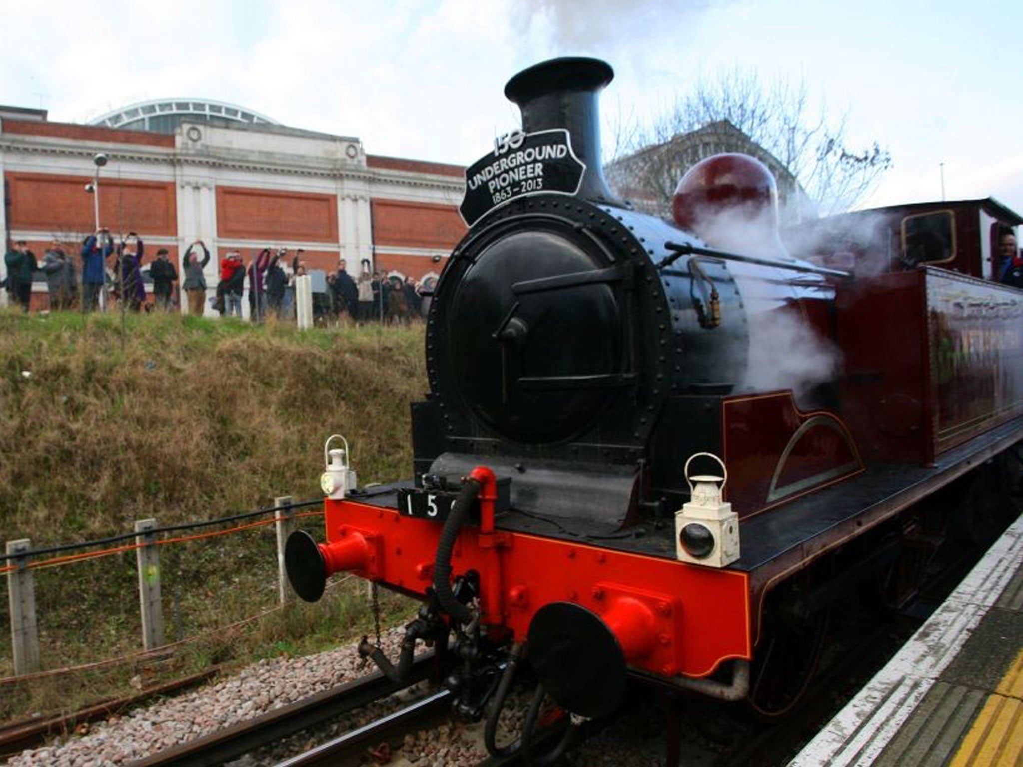 Train enthusiasts admiring a 19th century Met Locomotive No 1 steam engine