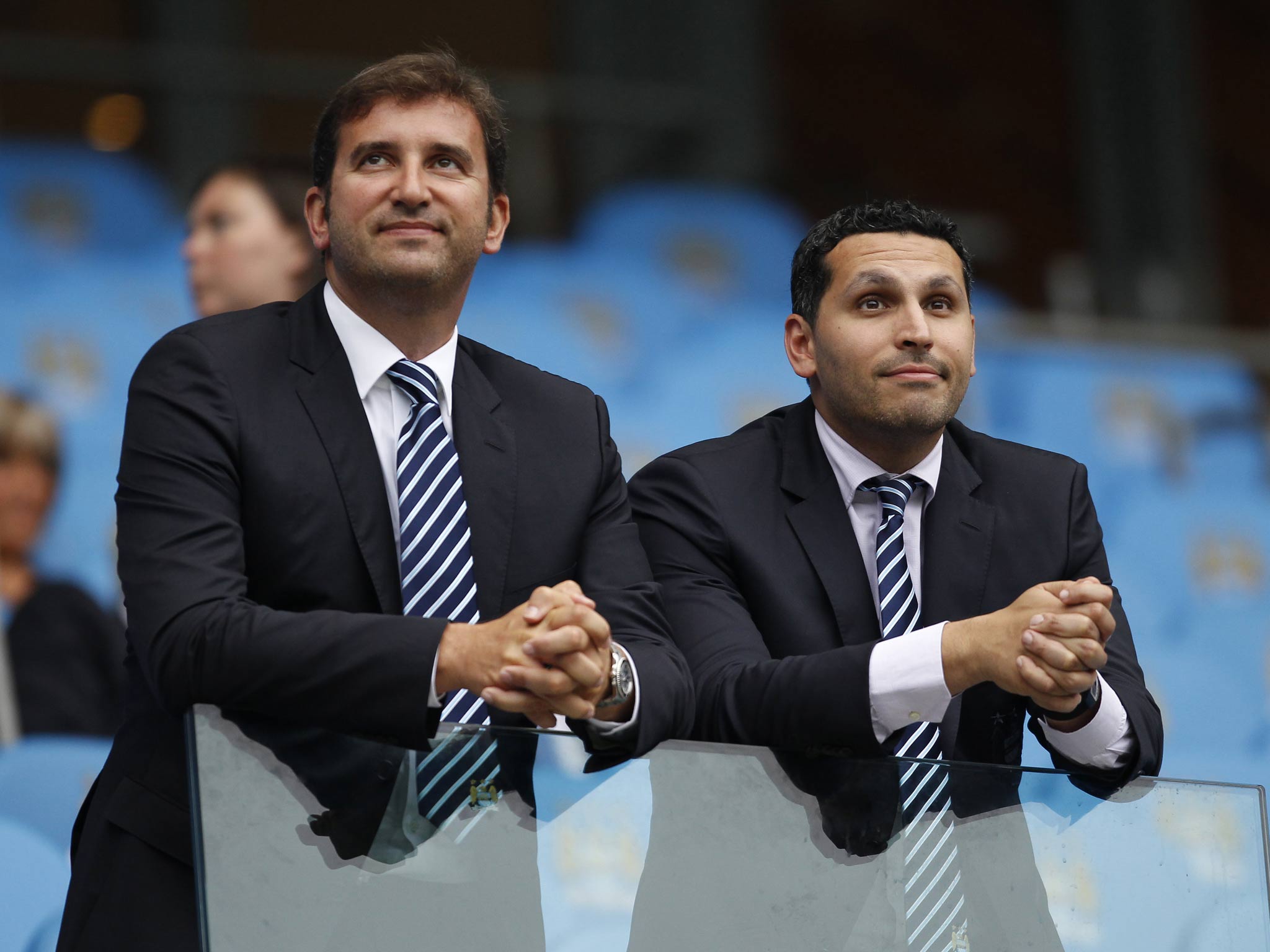 The chairman of Manchester City, Khaldoon Al Mubarak (R), talks to chief executive Ferran Soriano