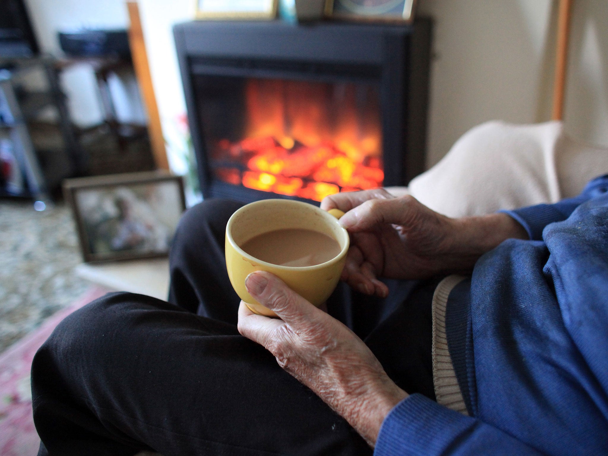 In this photo illustration, an elderly man warms himself in front of a fire on October 6, 2011 in Bristol, England.