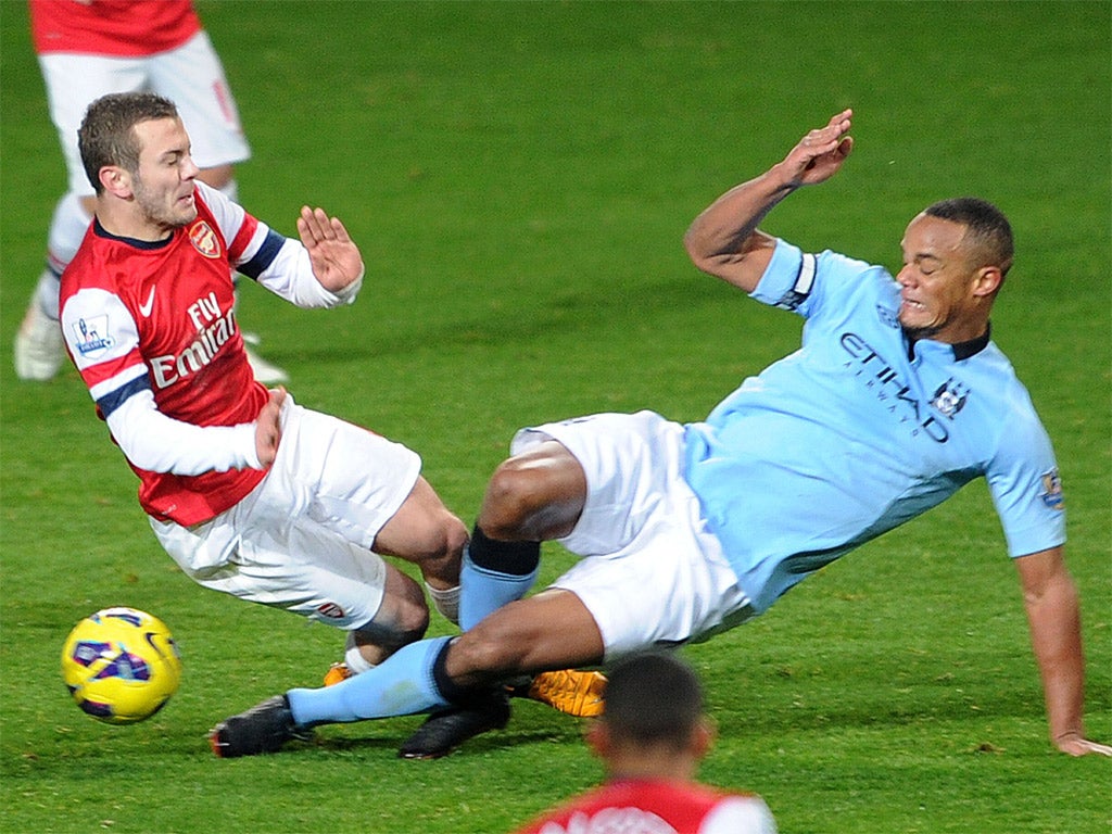 Vincent Kompany slides in on Jack Wilshere