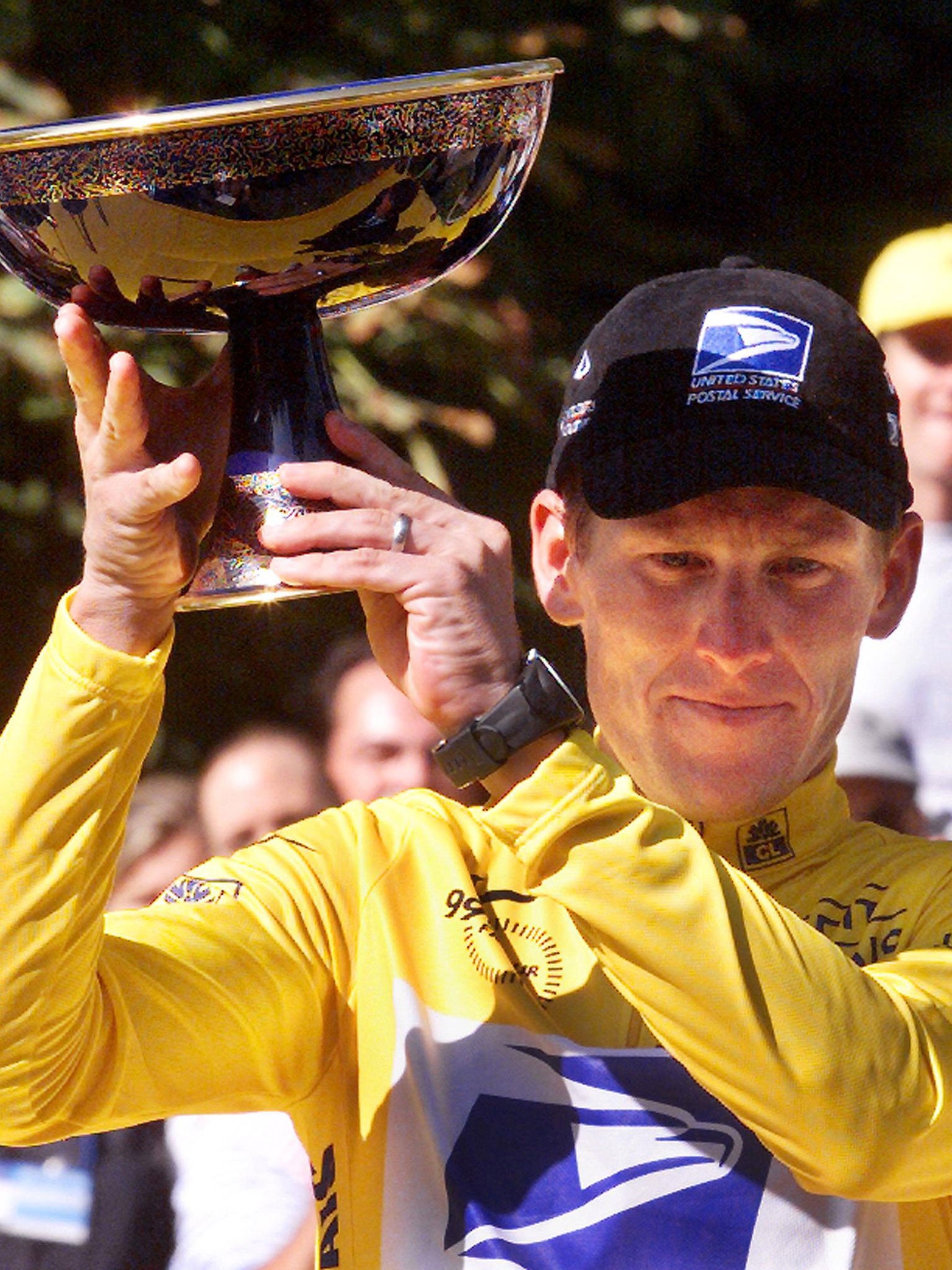 Lance Armstrong celebrates with trophy after wining his first Tour of France title in 1999