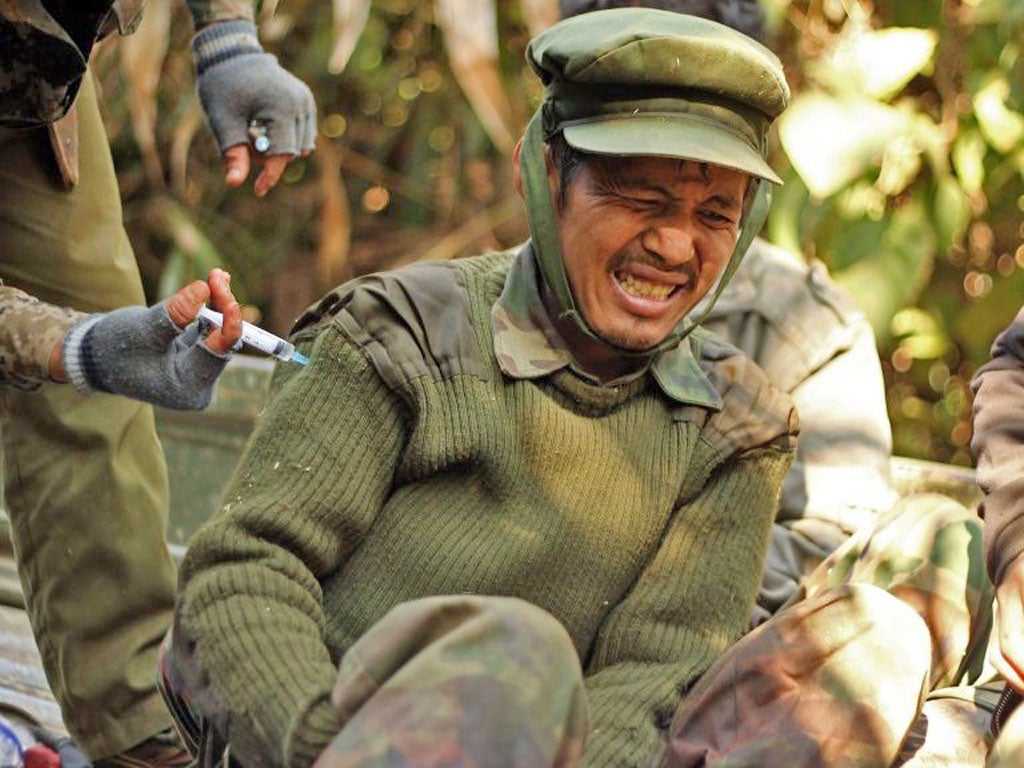 An injured Kachin Independence Army soldier is treated on Hka Ya
mountain yesterday