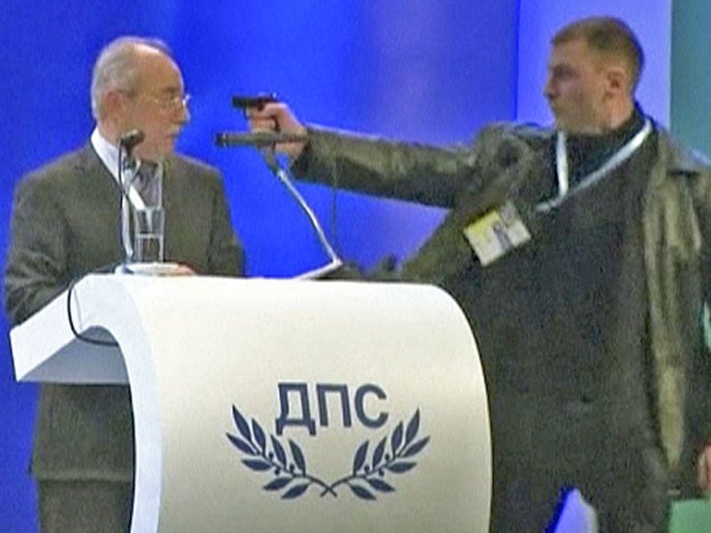 An unidentified man (right) attacks Ahmed Dogan, leader of Bulgaria's Movement for Rights and Freedom (MRF) party, as he delivers his speech during his party's annual conference at the National Palace of Culture in Sofia