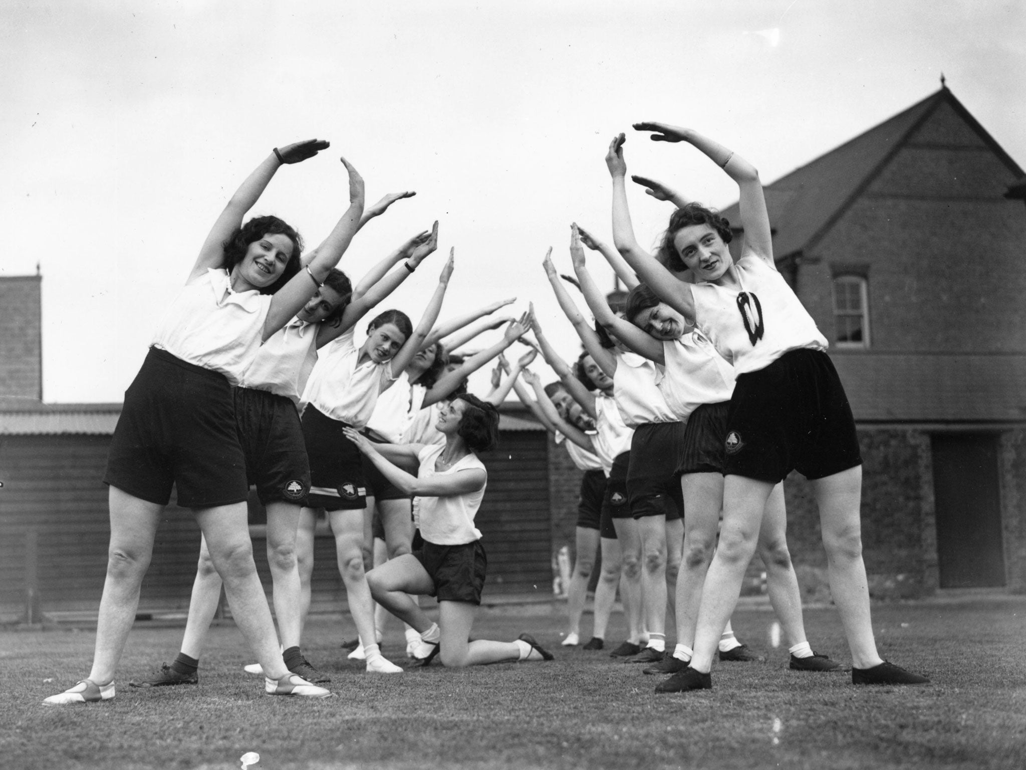 24th May 1933: Ruby Hillary, putting her health and beauty class through their slimming exercises at Bounds Green School, London.