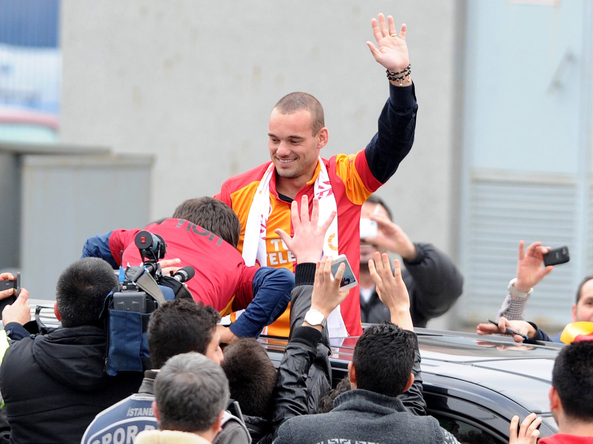 Wesley Sneijder is welcomed by Galatarasay supporters after his arrival at Ataturk airport