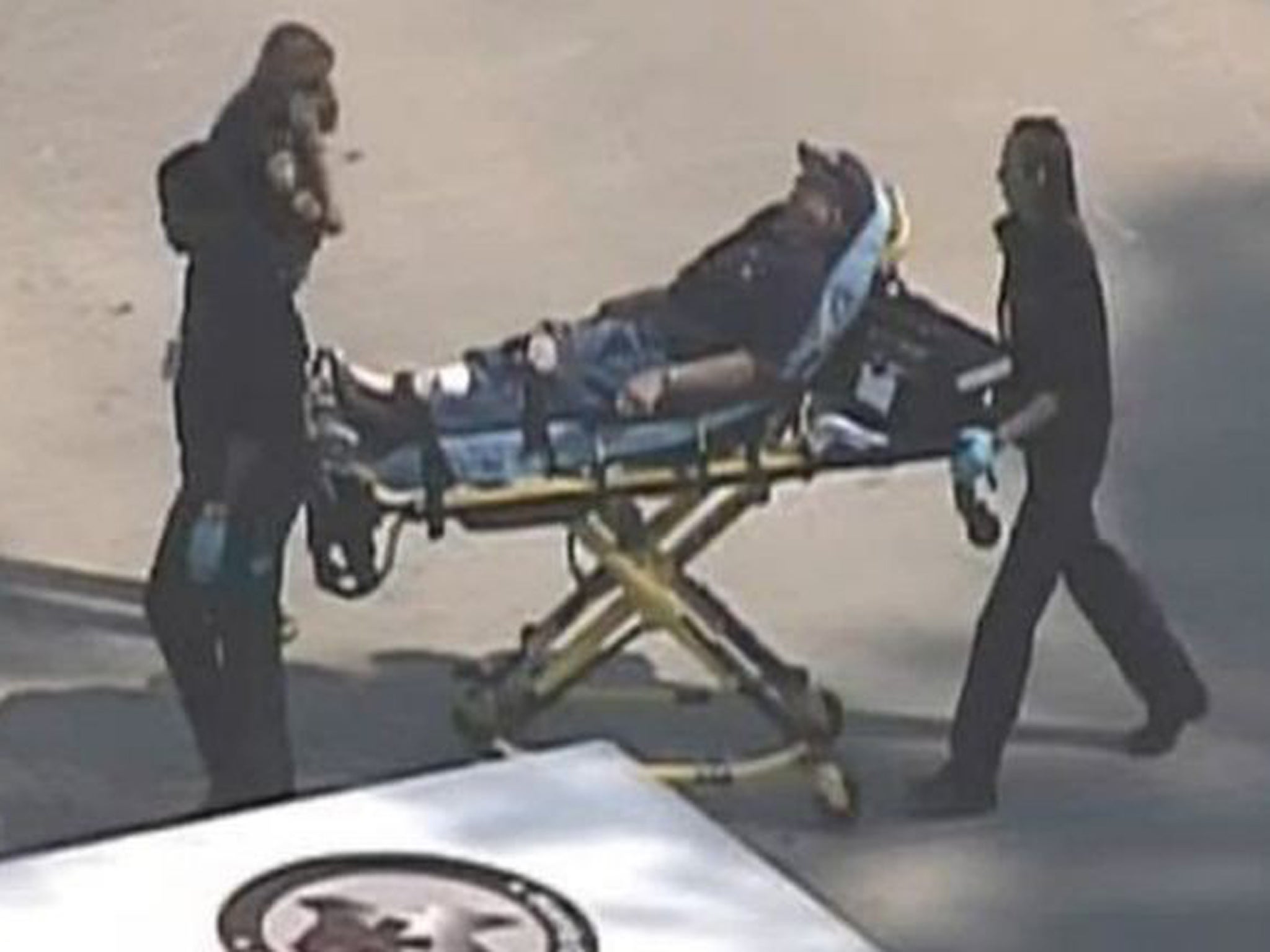 Police and emergency personnel evacuate an injured male on a stretcher outside a building on the Lone Star College Campus