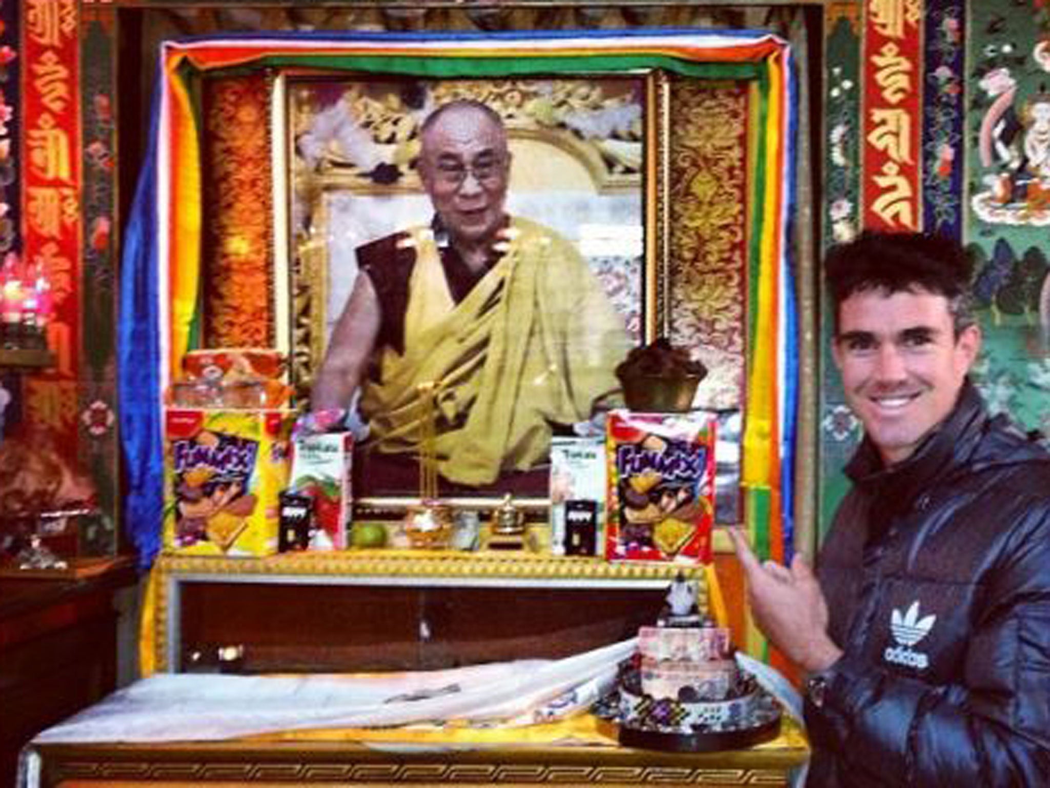 Kevin Pietersen poses in front of a picture of the Dalai Lama at the McLeod Ganj Buddhist Temple