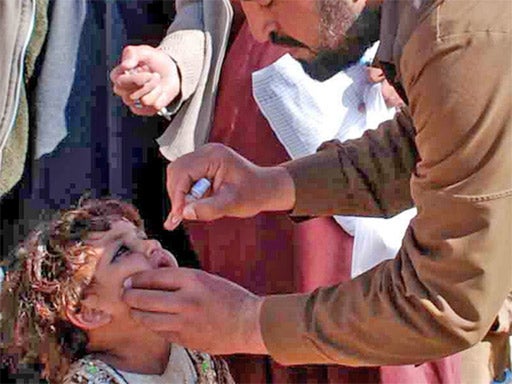 A vaccinator inoculates a child against polio in Pakistan