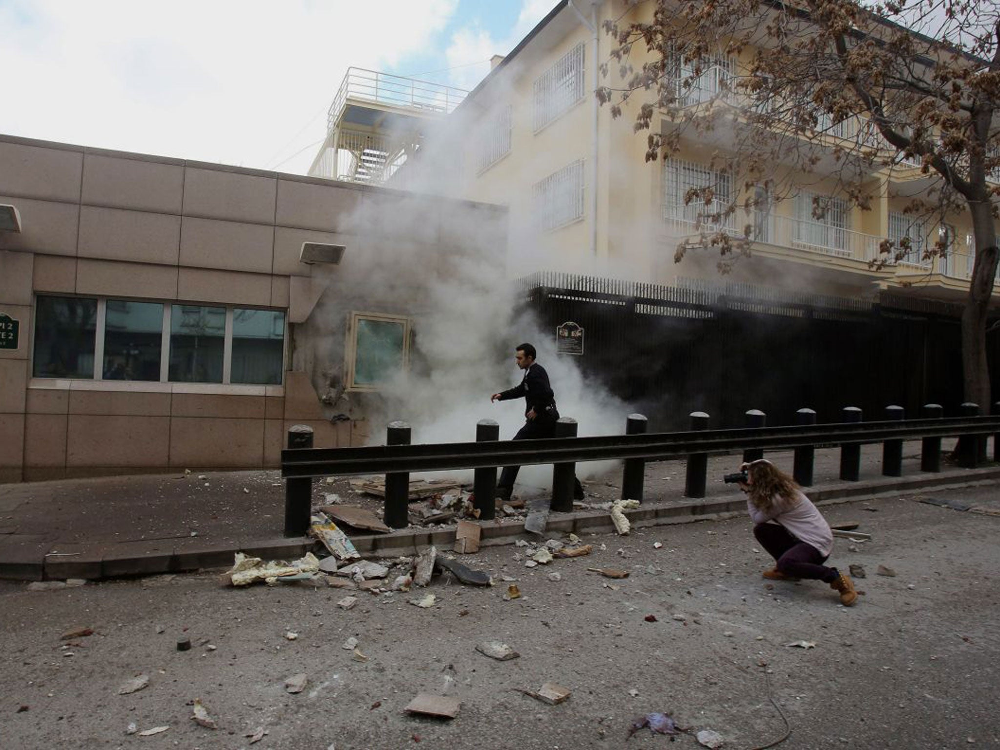 An embassy security guard arrives at the Gate 2 of the US embassy just minutes after a suicide bomber has detonated an explosive device at the entrance of the U.S. Embassy