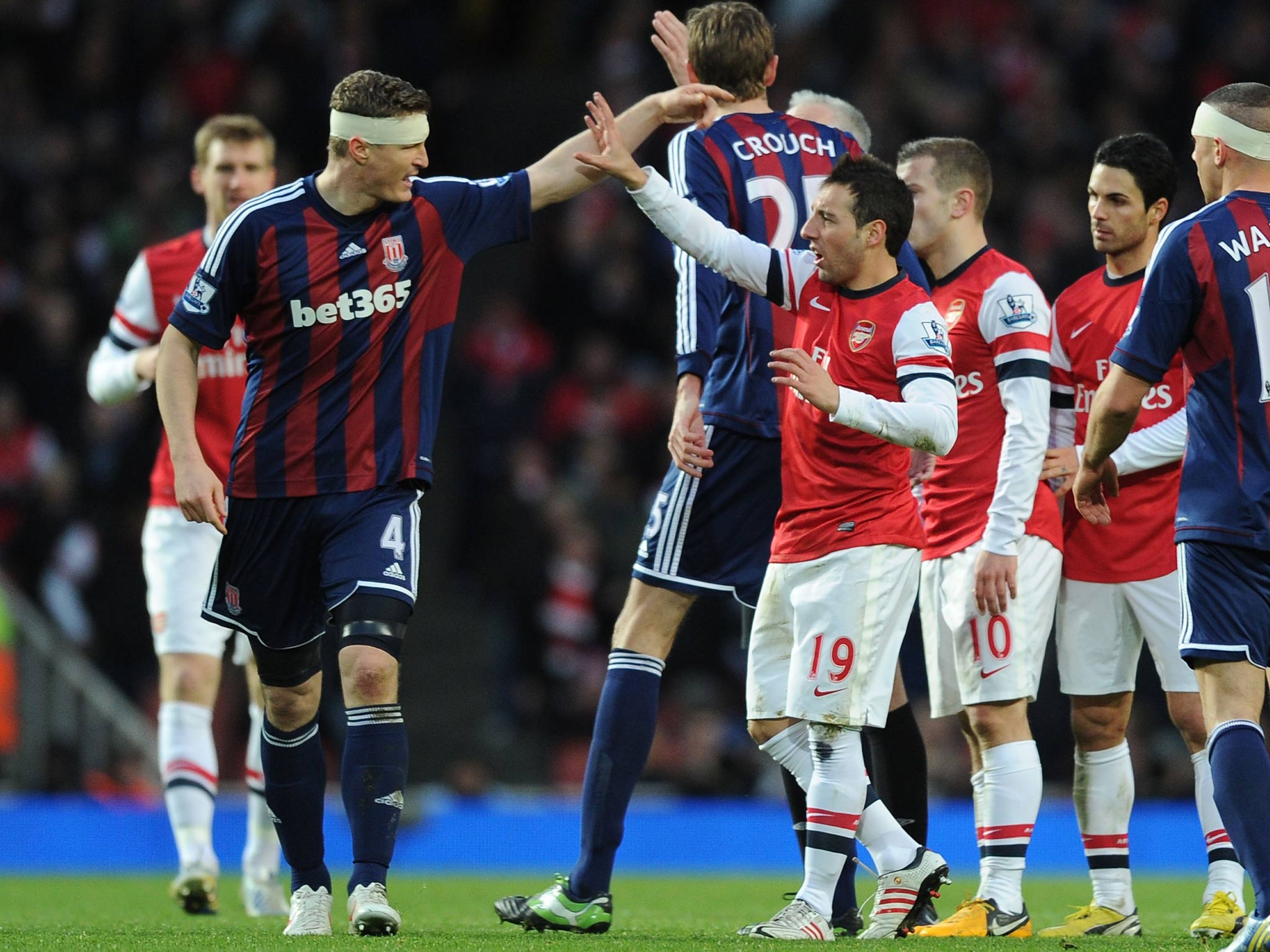 Santi Cazorla of Arsenal clashes with Robert Huth of Stoke during the Barclays Premier League match