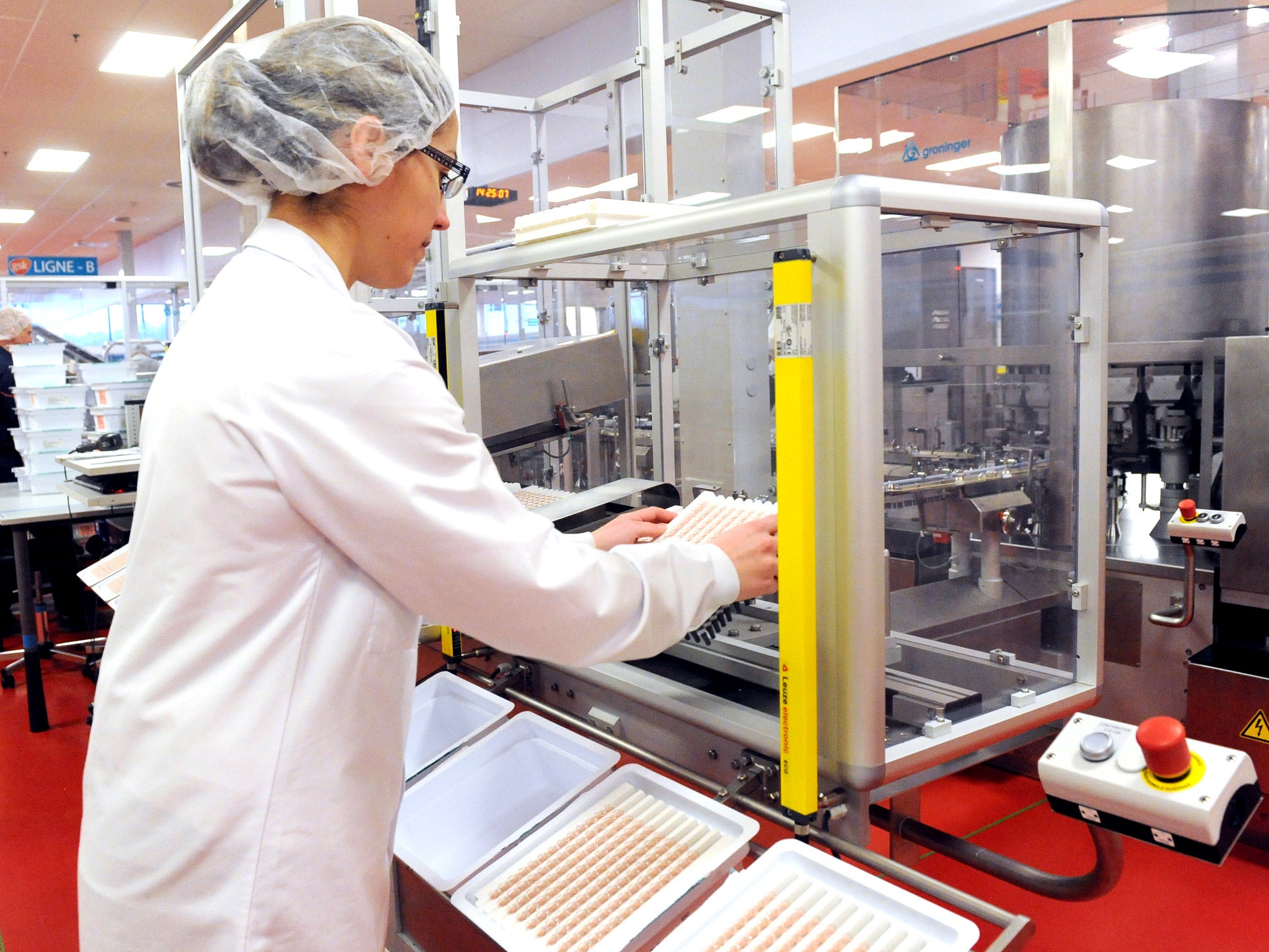 A woman at work at a GlaxoSmithKline vaccine production line