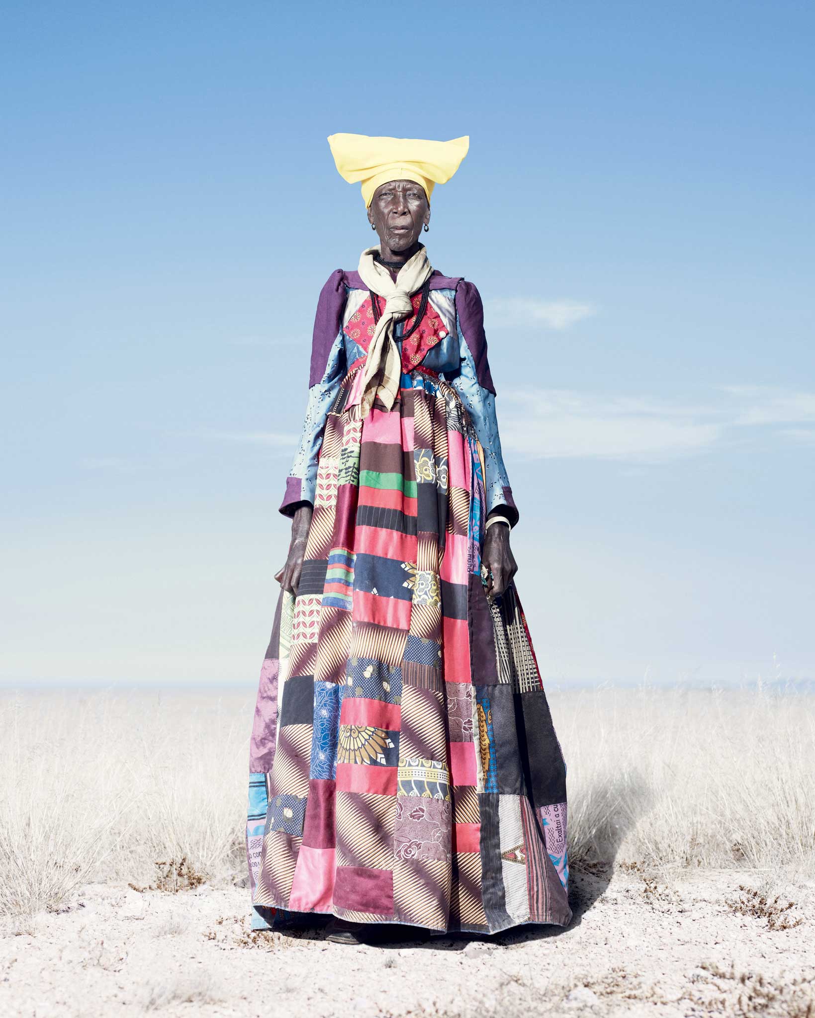 An elderly Herero woman in a patchwork dress that would be worn every day of the year; as Herero women get older,
the 'horns' of their headdresses get smaller. According to some accounts, this symbolises their loss of fertility