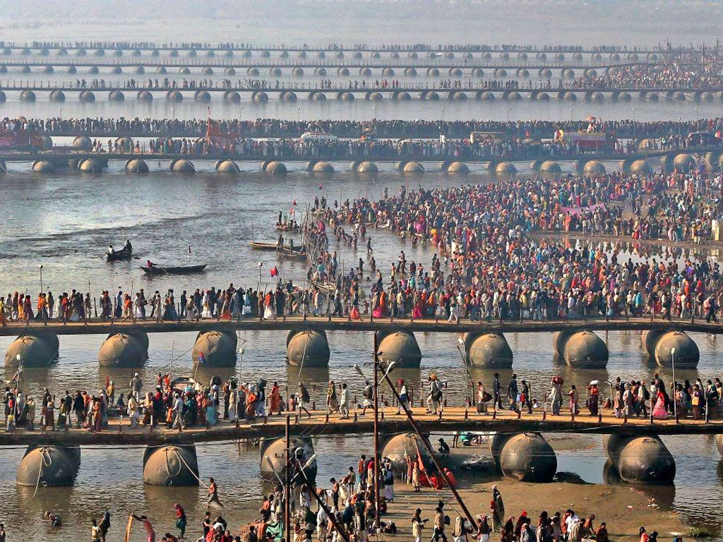 Hindu devotees walk across pontoon bridges at Sangam