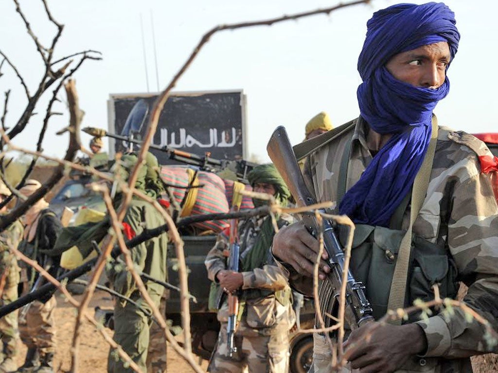 A Malian soldier stands guard at a check-point set on the road leading to Bourem in Gao, one day after Islamist gunmen battled French and Malian troops following two straight days of suicide bombings