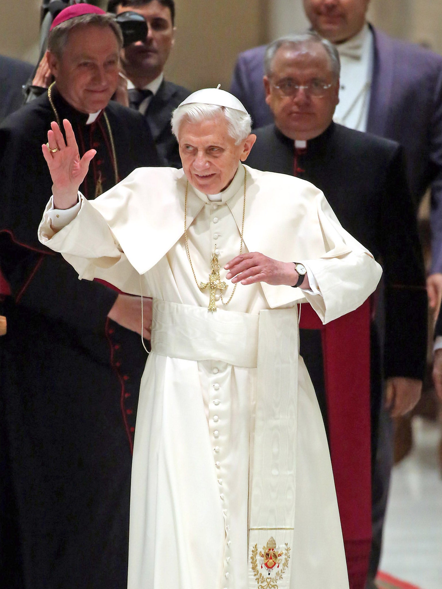 The Pope waves to the faithful as he arrives at the Paul VI Hall