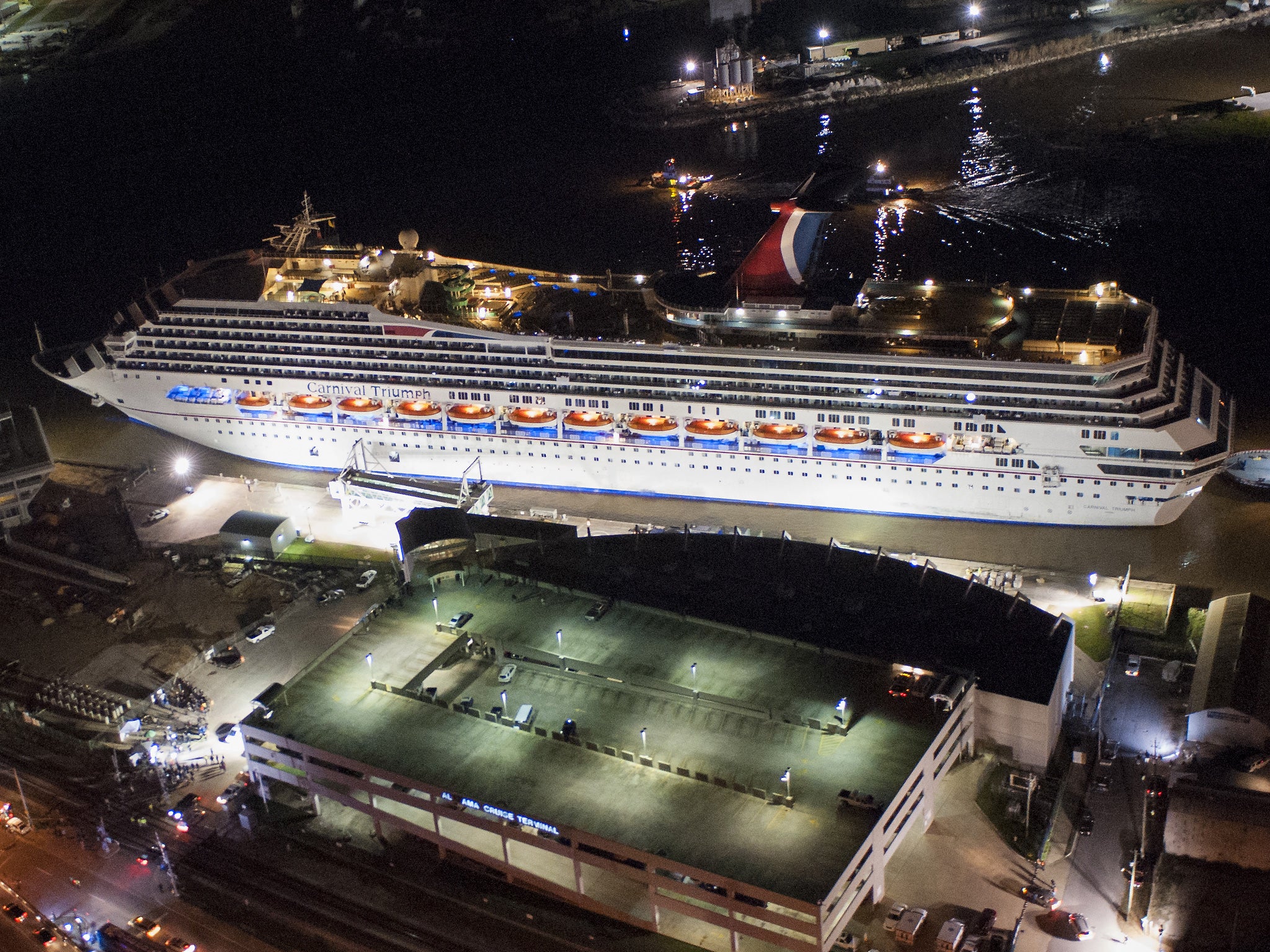 The crippled cruise liner Carnival Triumph limps into port guided by tug boats in Mobile, Alabama