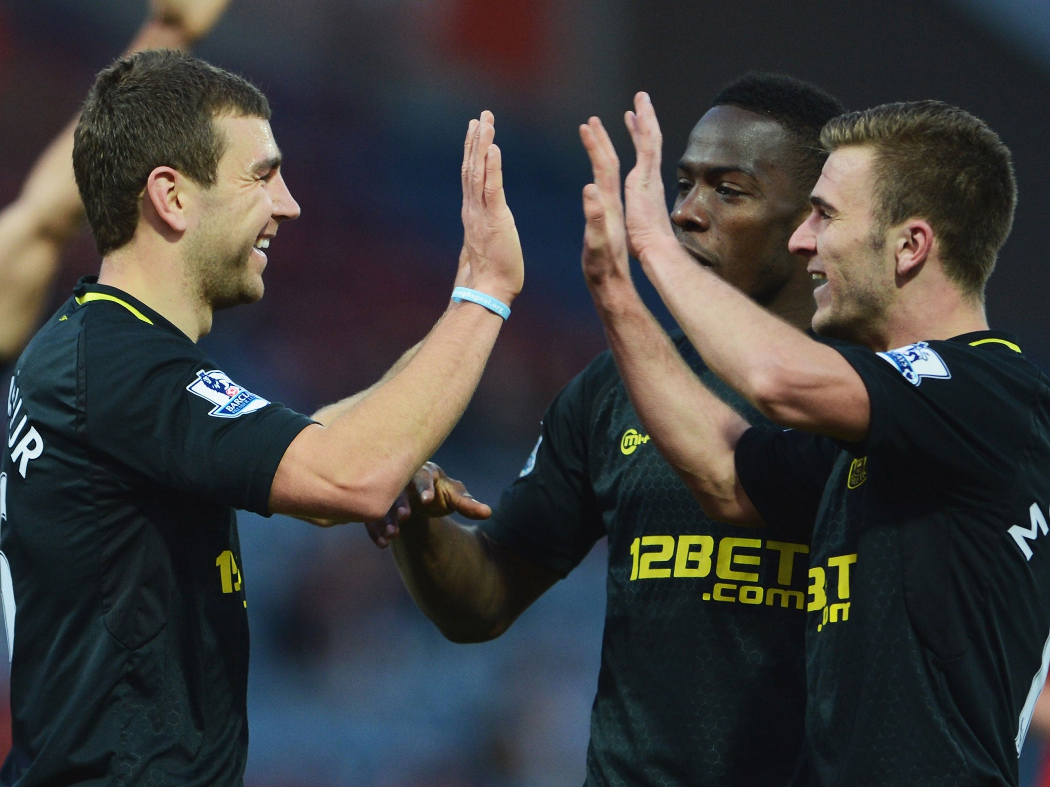 James McArthur of Wigan Athletic (L) celebrates with Maynor Figueroa (C) and Callum McManaman (R) as he scores their third goal