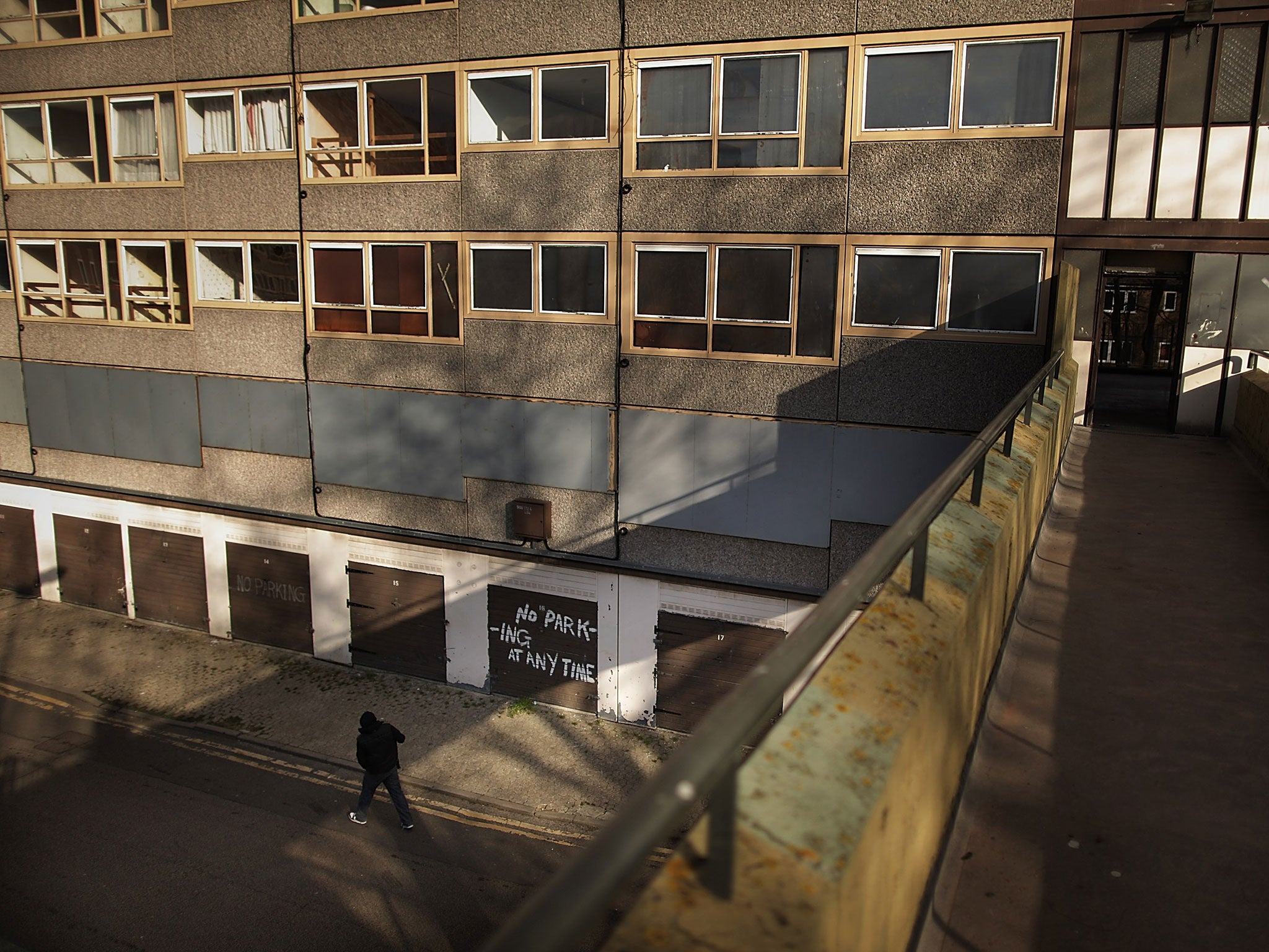 A man walks in late afternoon sunshine on the Heygate housing estate near Elephant and Castle on February 11, 2010 in London, England.