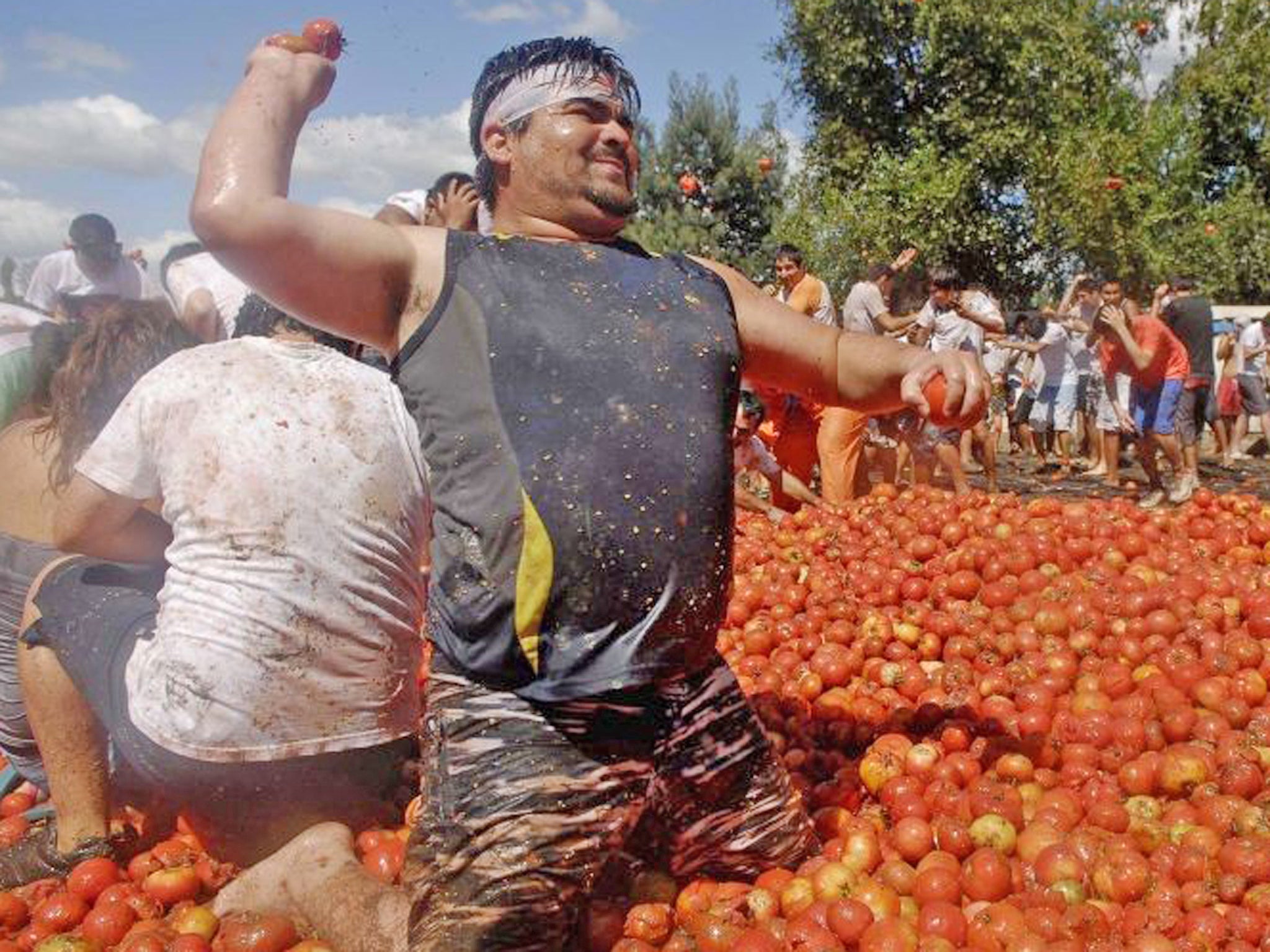 Revellers play with tomatoes during a "Tomatina" (tomato fight) in Quillon town near Concepcion city, south of Santiago