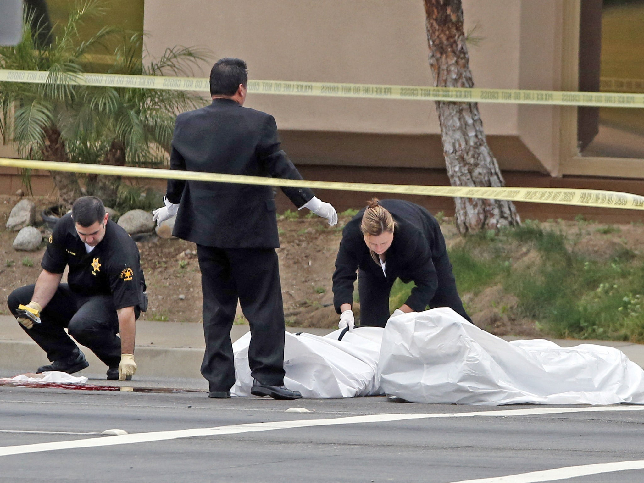 Orange County coroner's officials remove a body from the scene