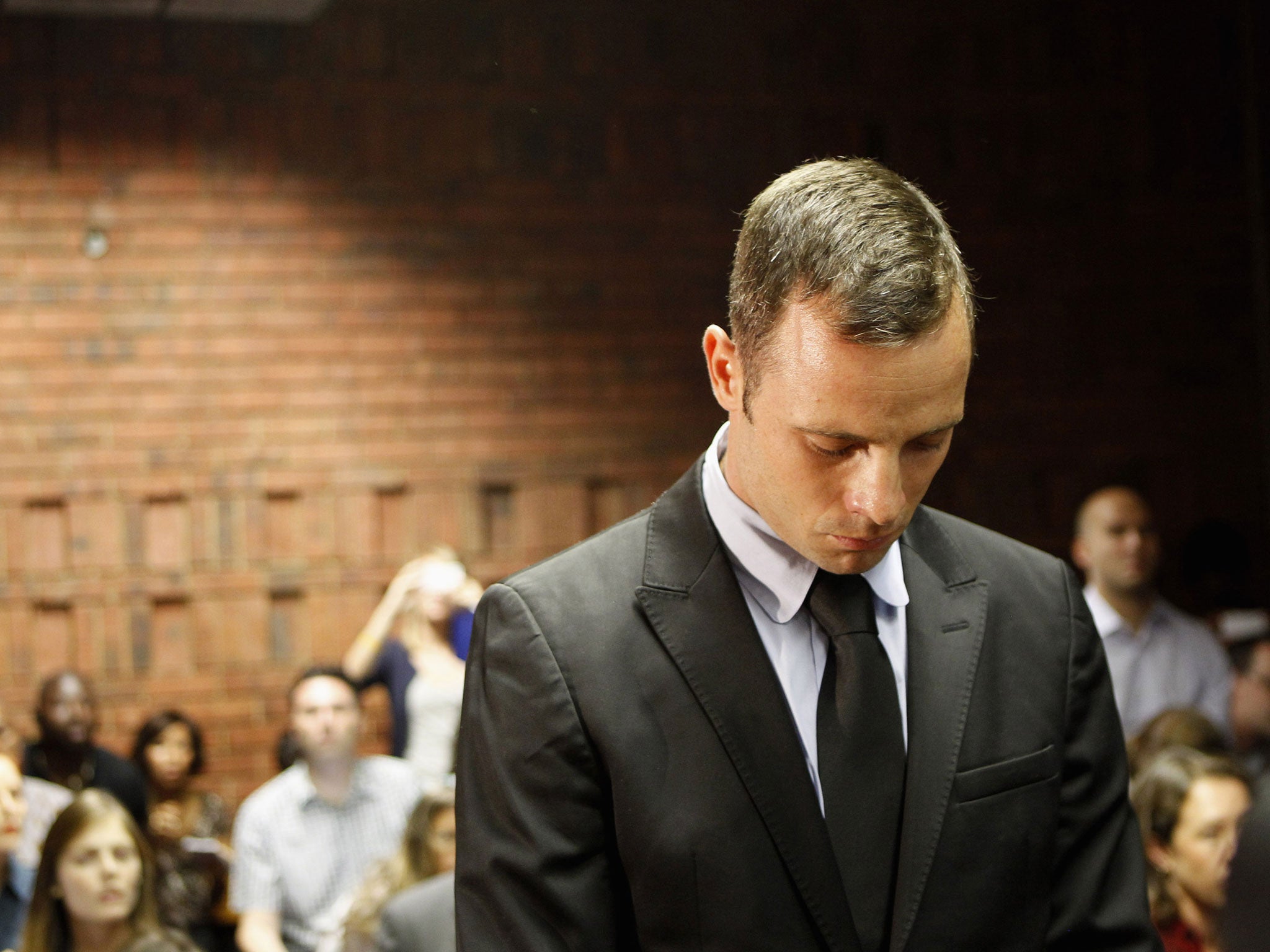 February 20, 2013: Oscar Pistorius stands in the dock during a break in court proceedings at the Pretoria Magistrates court