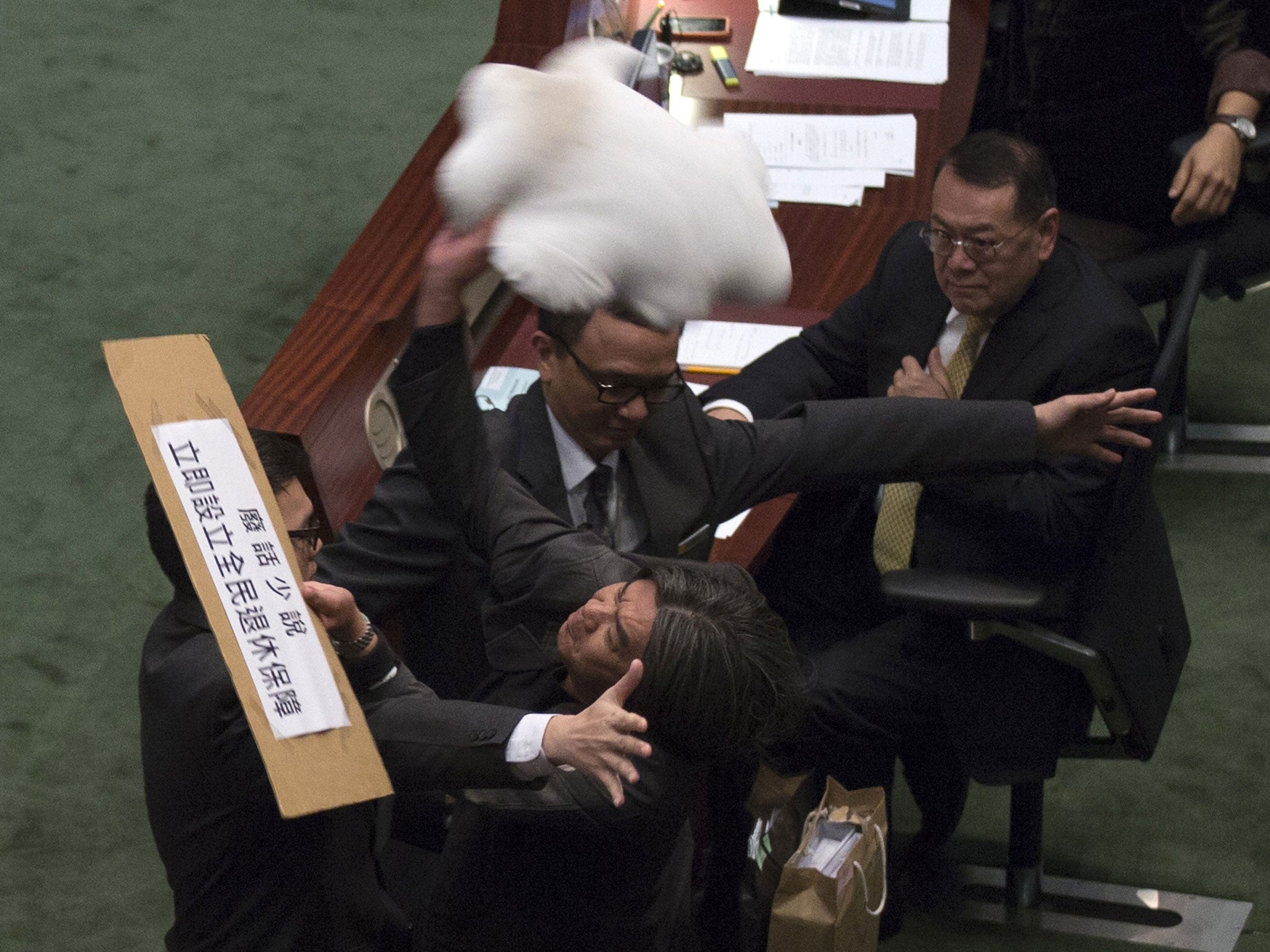 Pro-democracy lawmaker Leung Kwok-hung throws a cloud-shape cushion at Hong Kong's Financial Secretary John Tsang to demand for a universal retirement protection scheme during the annual budget report at the Legislative Council in Hong Kong February 27, 2013