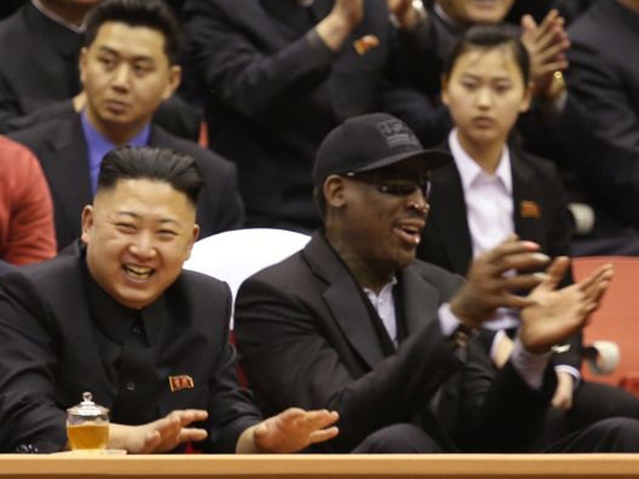 North Korean leader Kim Jong-unn, left, and former basketball star Dennis Rodman watch North Korean and U.S. players in an exhibition basketball game at an arena in Pyongyang