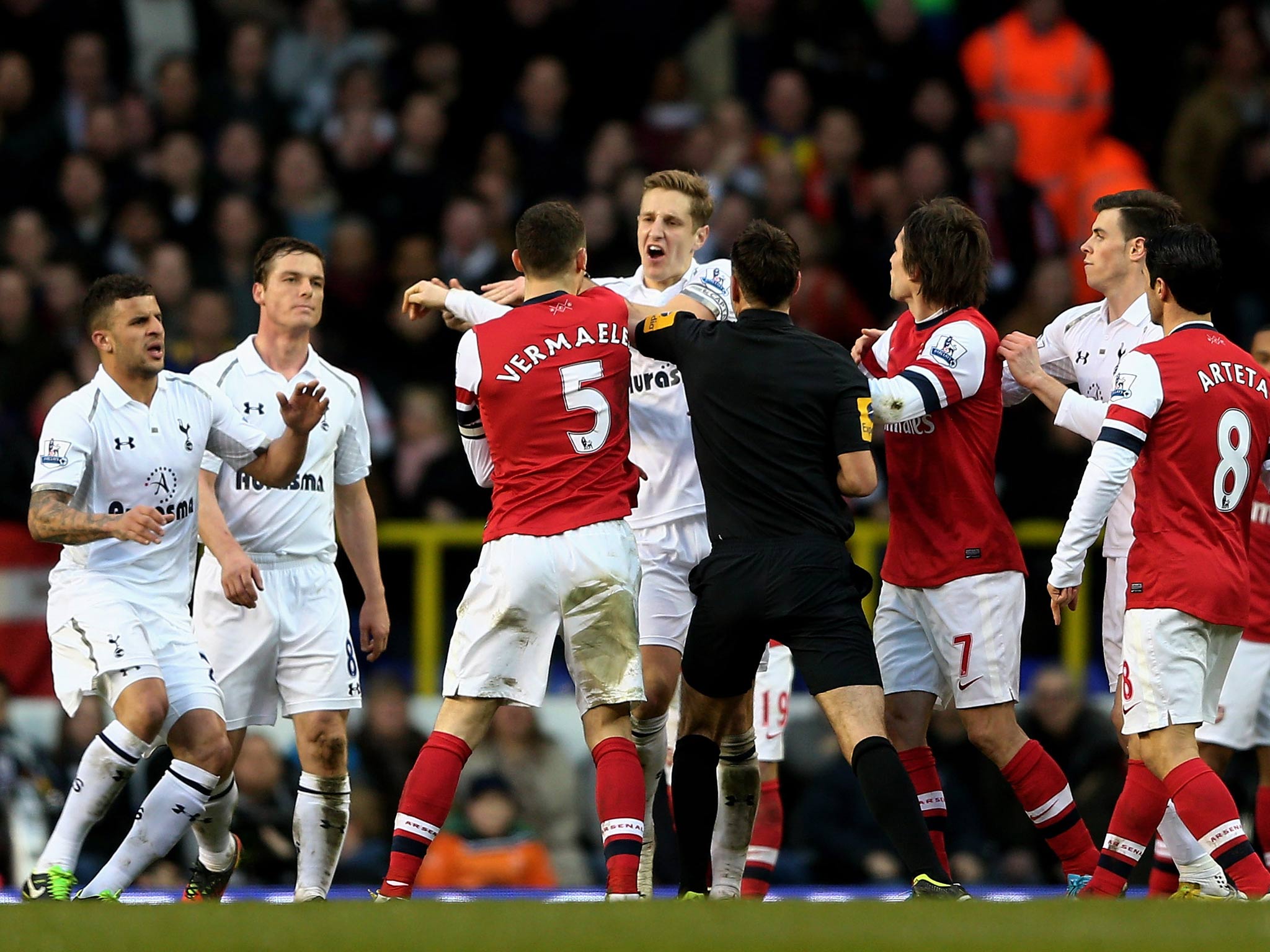 Opposing captains Thomas Vermaelen of Arsenal and Michael Dawson of Spurs clash