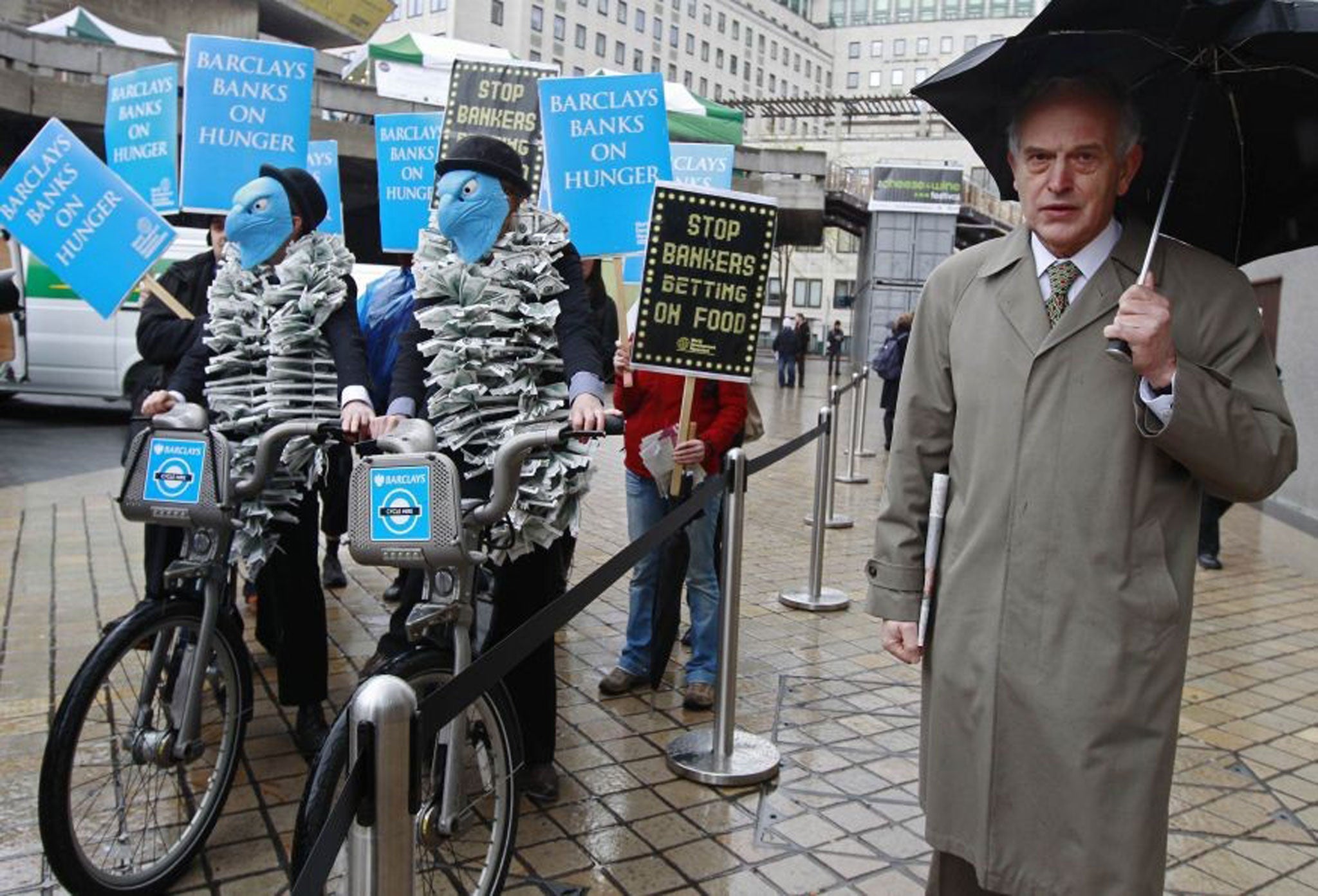 A Barclays shareholder passes demonstrators at the last AGM, where many investors rejected a pay plan