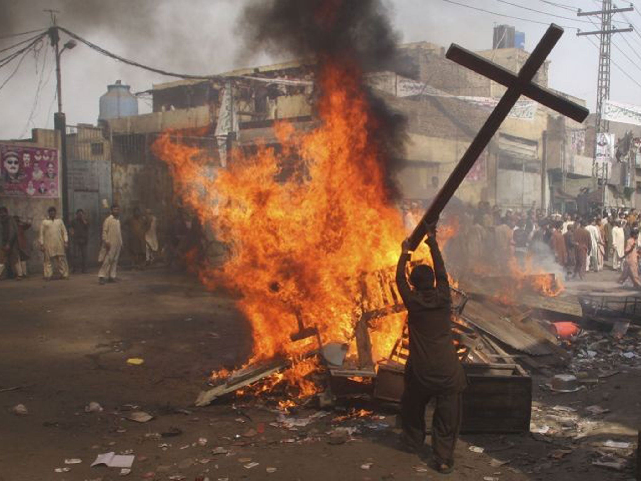 A Muslim demonstrator burns a cross in Badami Bagh on Saturday