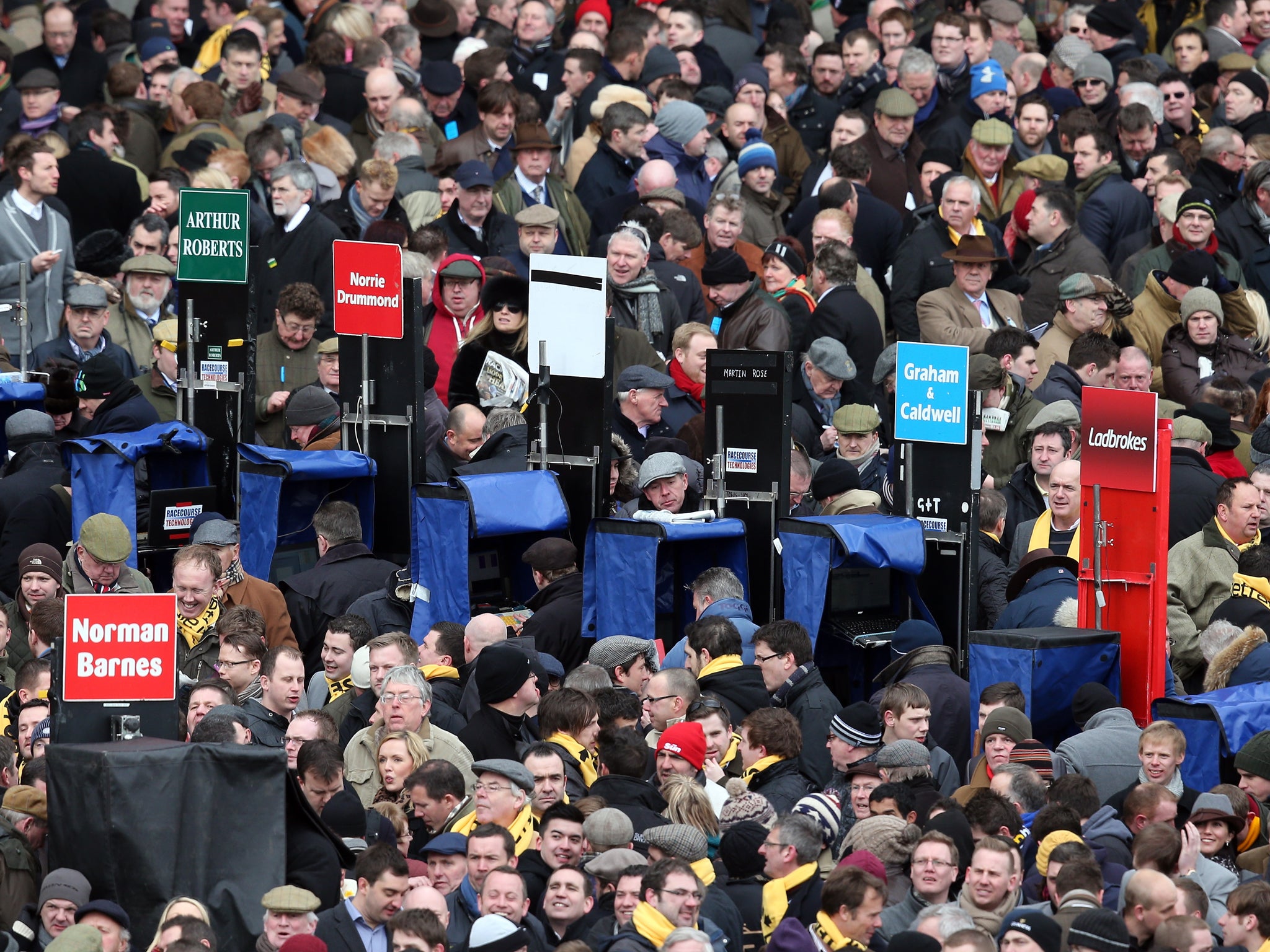 Race goers place bets with book makers at the Cheltenham racecourse on the first day of the Festival