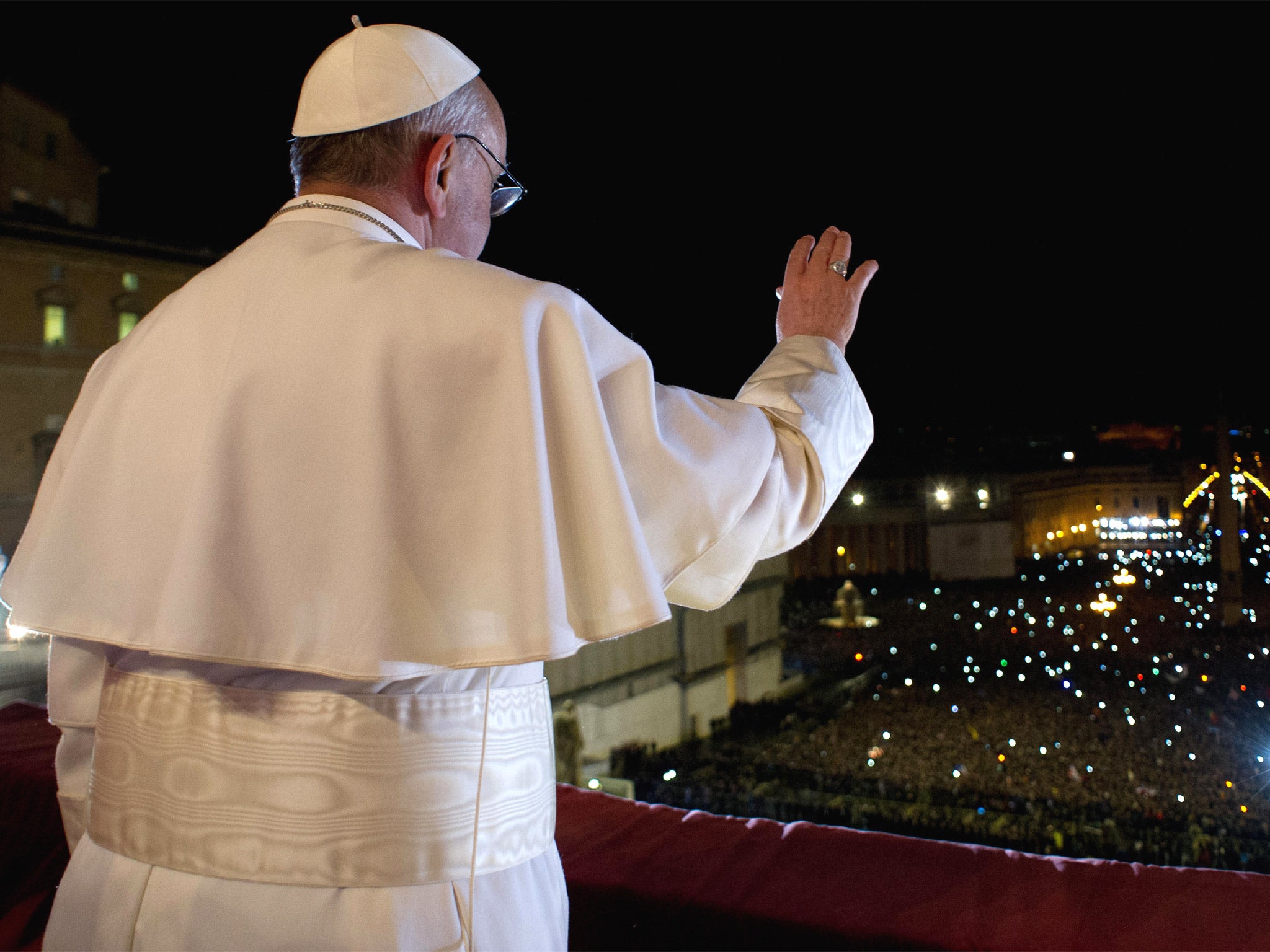 Pope Francis waves the crowd from the central balcony of St. Peter's Basilica