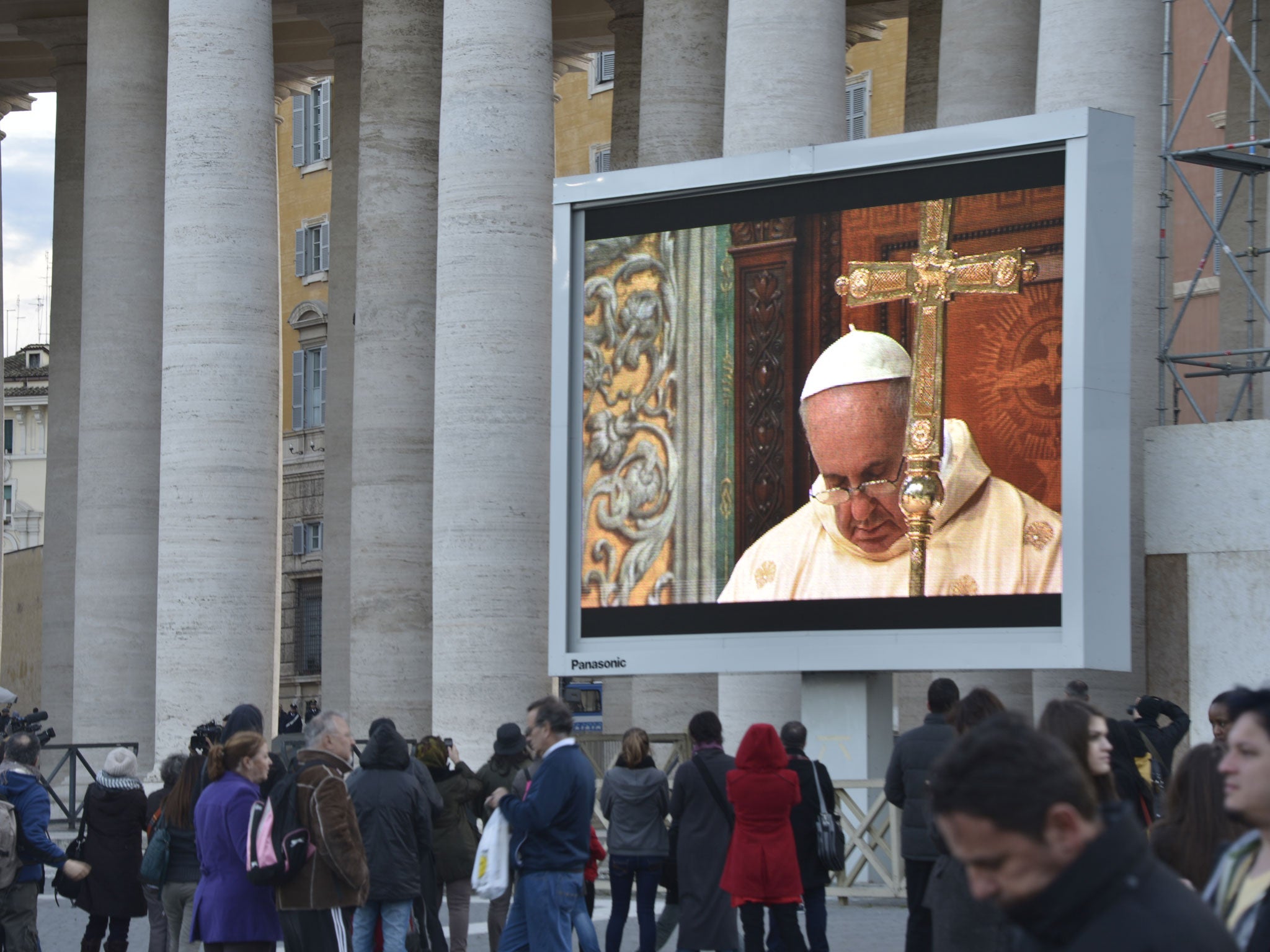 Faithful stand on St Peter's square to watch the first mass by Pope Francis on a giant screen on March 14, 2013 at the Vatican.