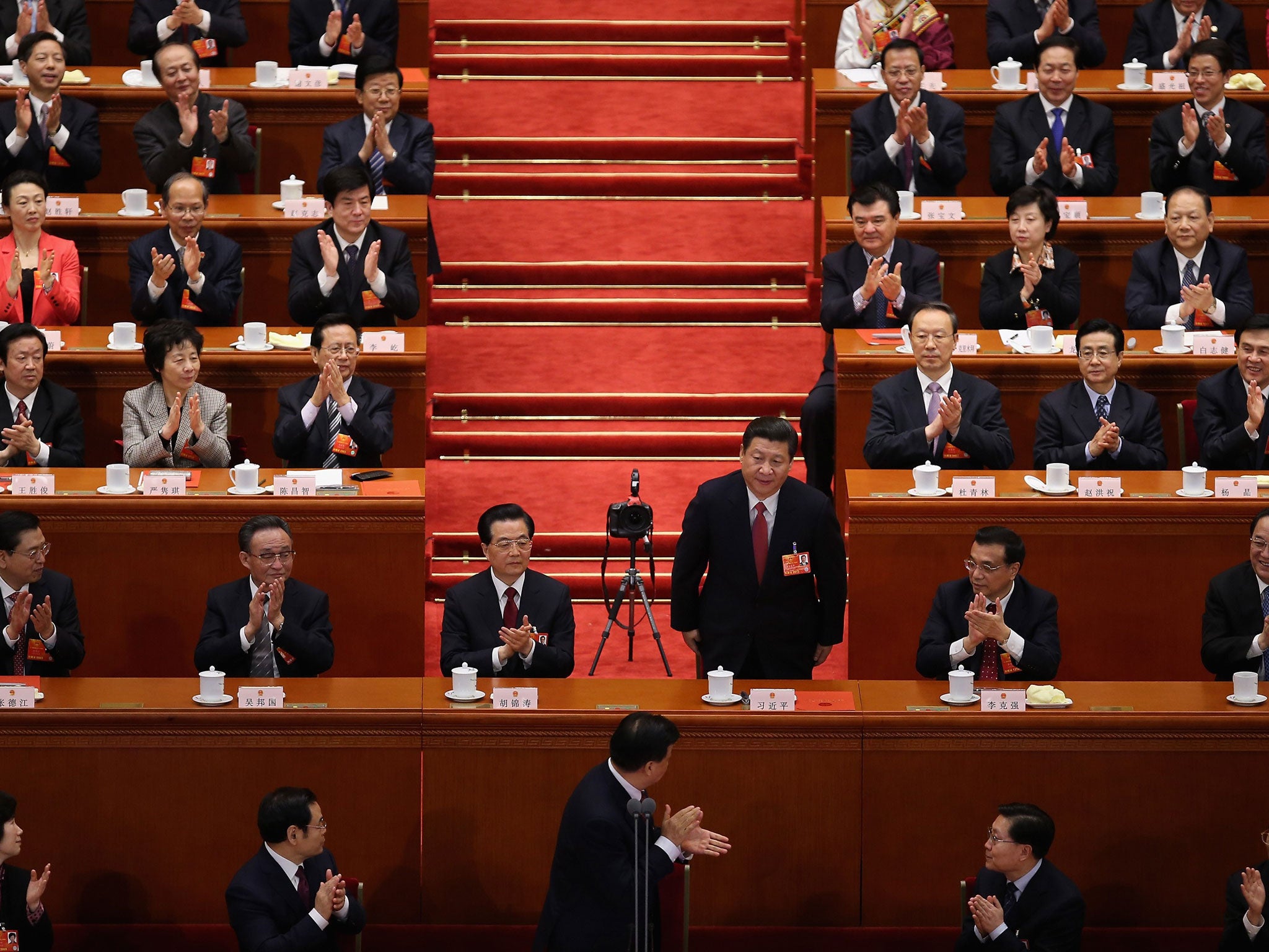 Newly elected President Xi Jinping is applauded by delegates