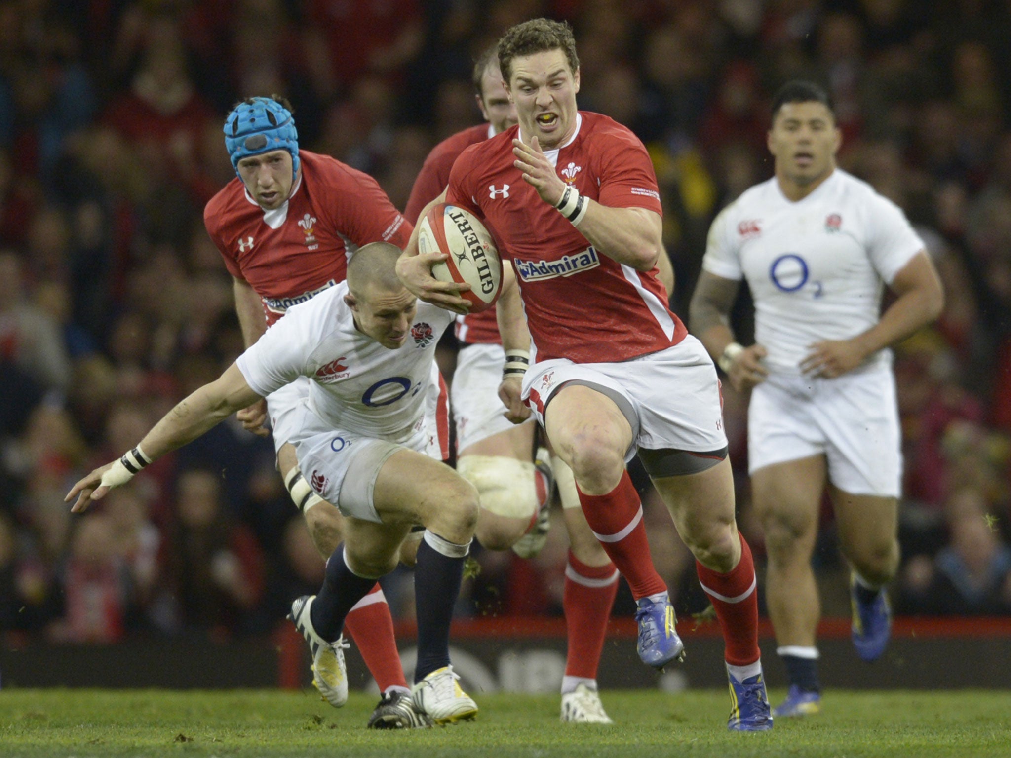 England's wing Mike Brown (L) runs in to make a last-ditch tackle against Wales's wing George North