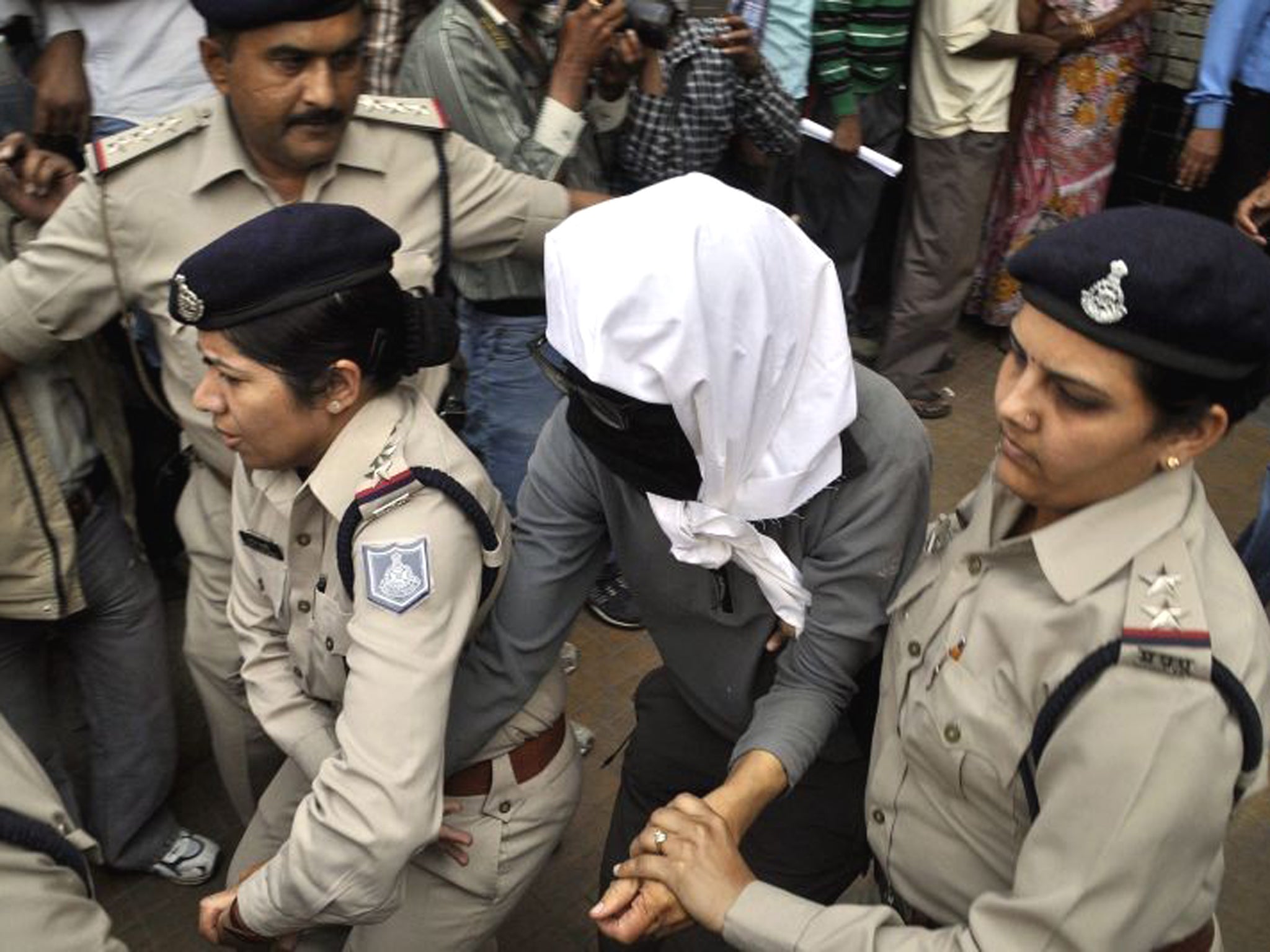 The victim has her face hidden
as she is taken for a medical
examination in Gwalior