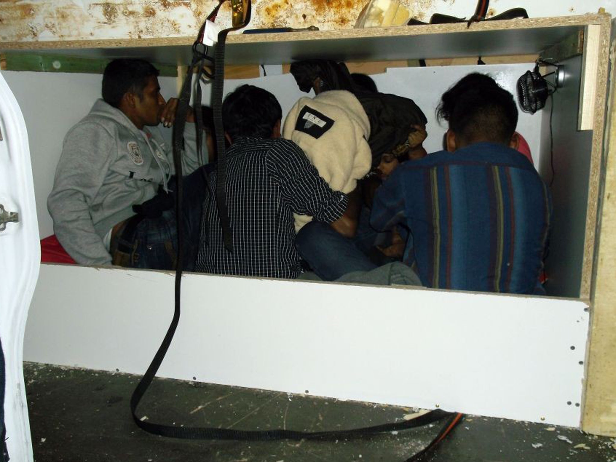 A photograph issued by the UK Border Agency of seven stowaways who were stopped from entering Britain after being found in a tiny purpose-built hideaway inside a van at the Port of Calais