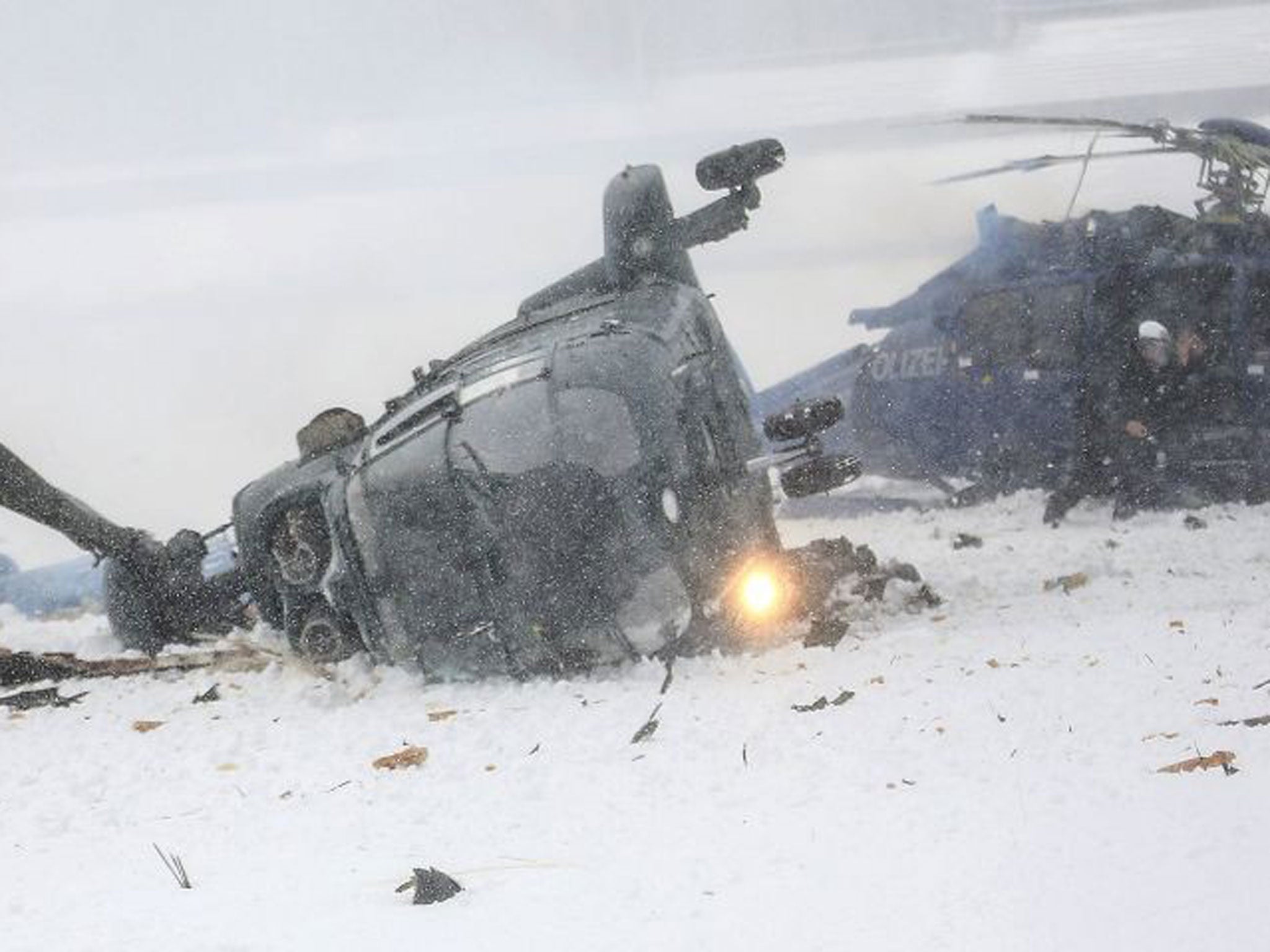 Rescue workers examine two crashed helicopters of the German federal police on a field at the Olympic Stadium in Berlin