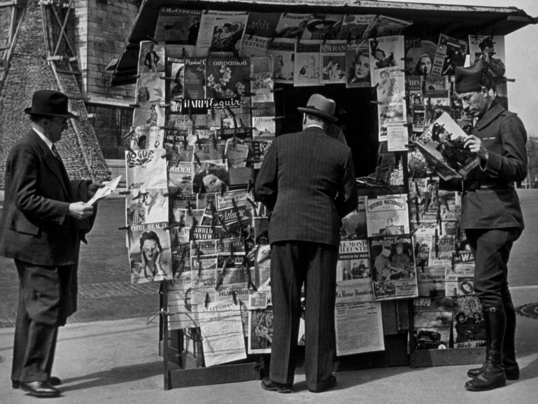 circa 1940: A soldier in Paris reading Picture Post at a newsstand.