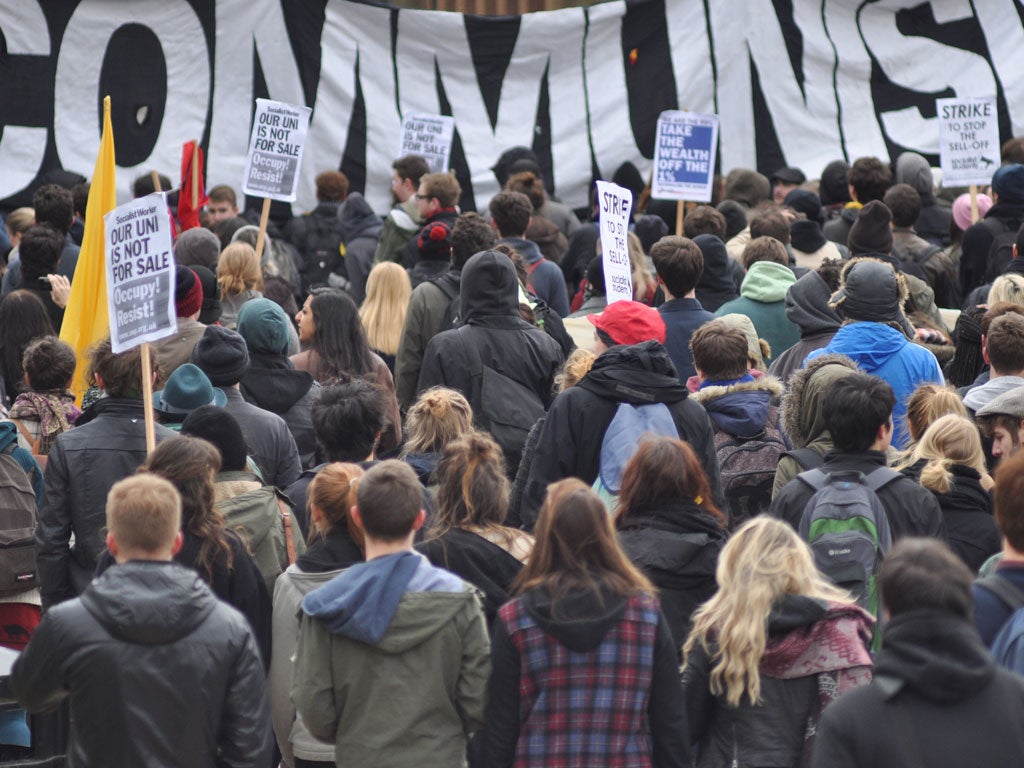 Protesters brandish placards in front of "communism" banner