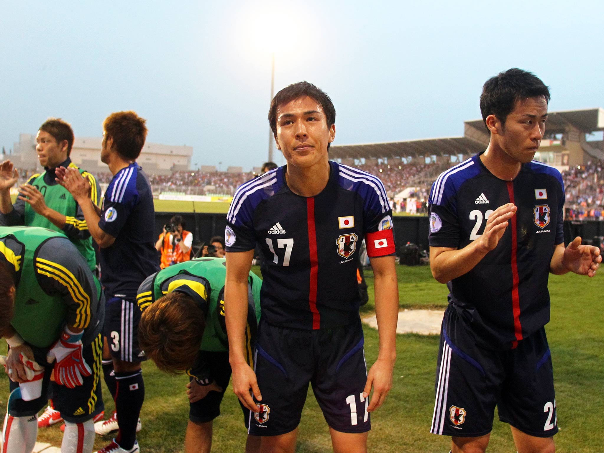 Makoto Hasebe (R) and Maya Yoshida of Japan walk off the field dejected after losing to Jordan