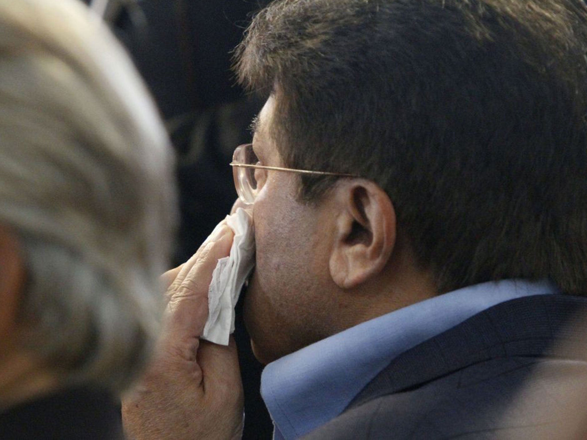 Former Pakistani President Pervez Musharraf wipes his face after a shoe was thrown at him as he headed to court to face legal charges in Karachi,