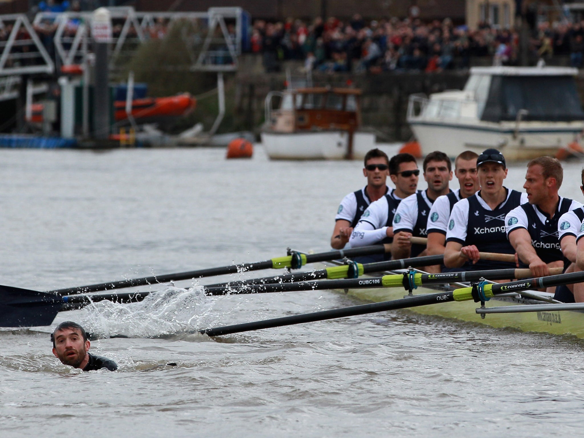 The Oxford crew look on as protester Trenton Oldfield swims in the water