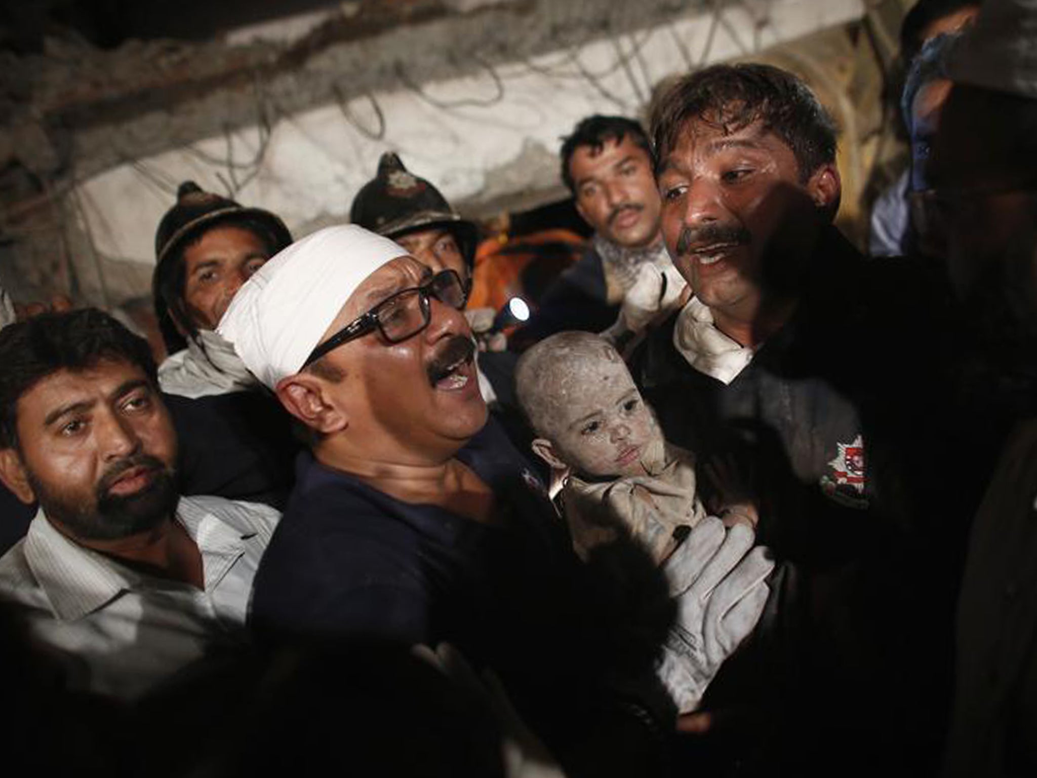 Rescue workers carry a child who survived from a collapsed residential building in Thane, on the outskirts of Mumbai