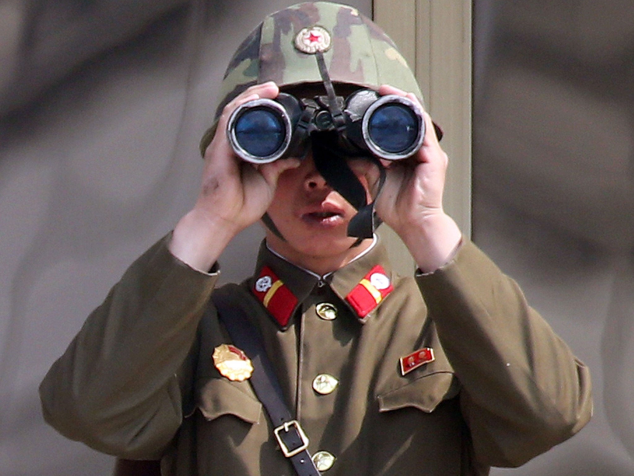 Guard duty: A North Korean soldier keeps watch on South Korea last week from the truce village of Panmunjom