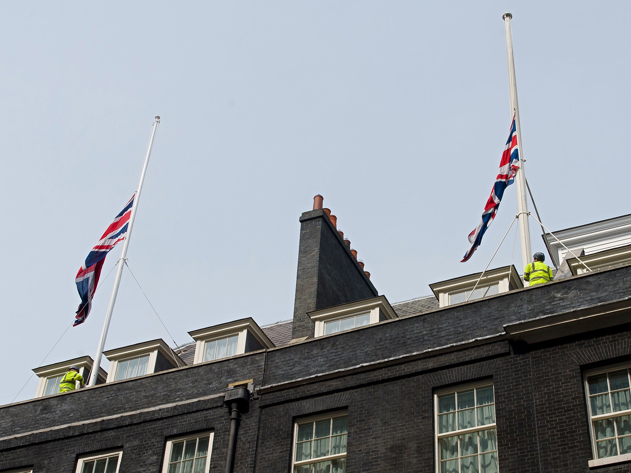 Workmen lower Britain's Union flags to half-mast above 10 Downing Street
