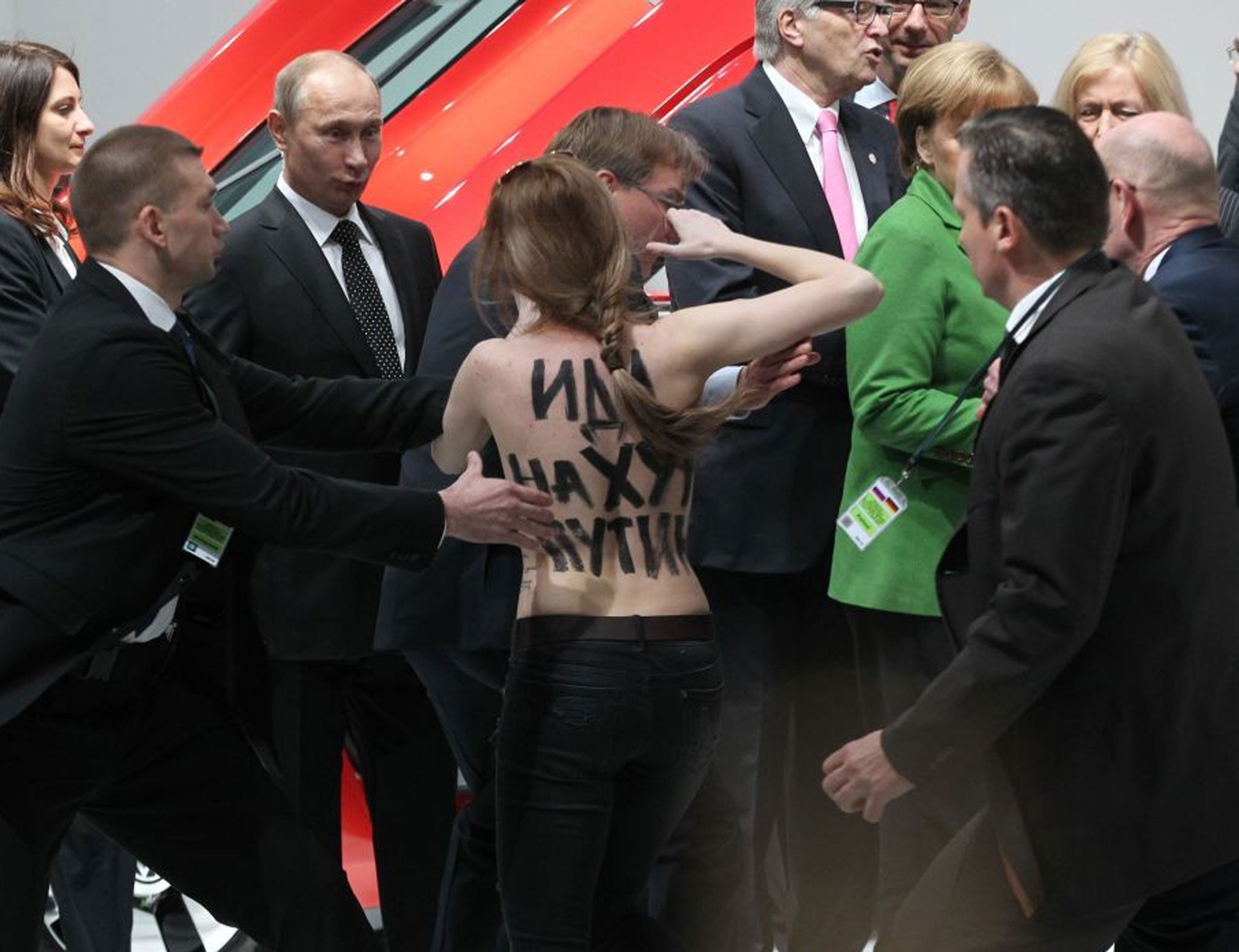 Russian Prime Minister Vladmir Putin is accosted by a topless protester